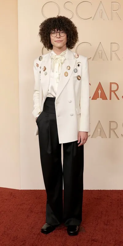 <p>Reece Feldman wears vintage brooches and Omega 30mm Seamaster Aqua Terra in Moonshine Gold, set with diamonds</p>