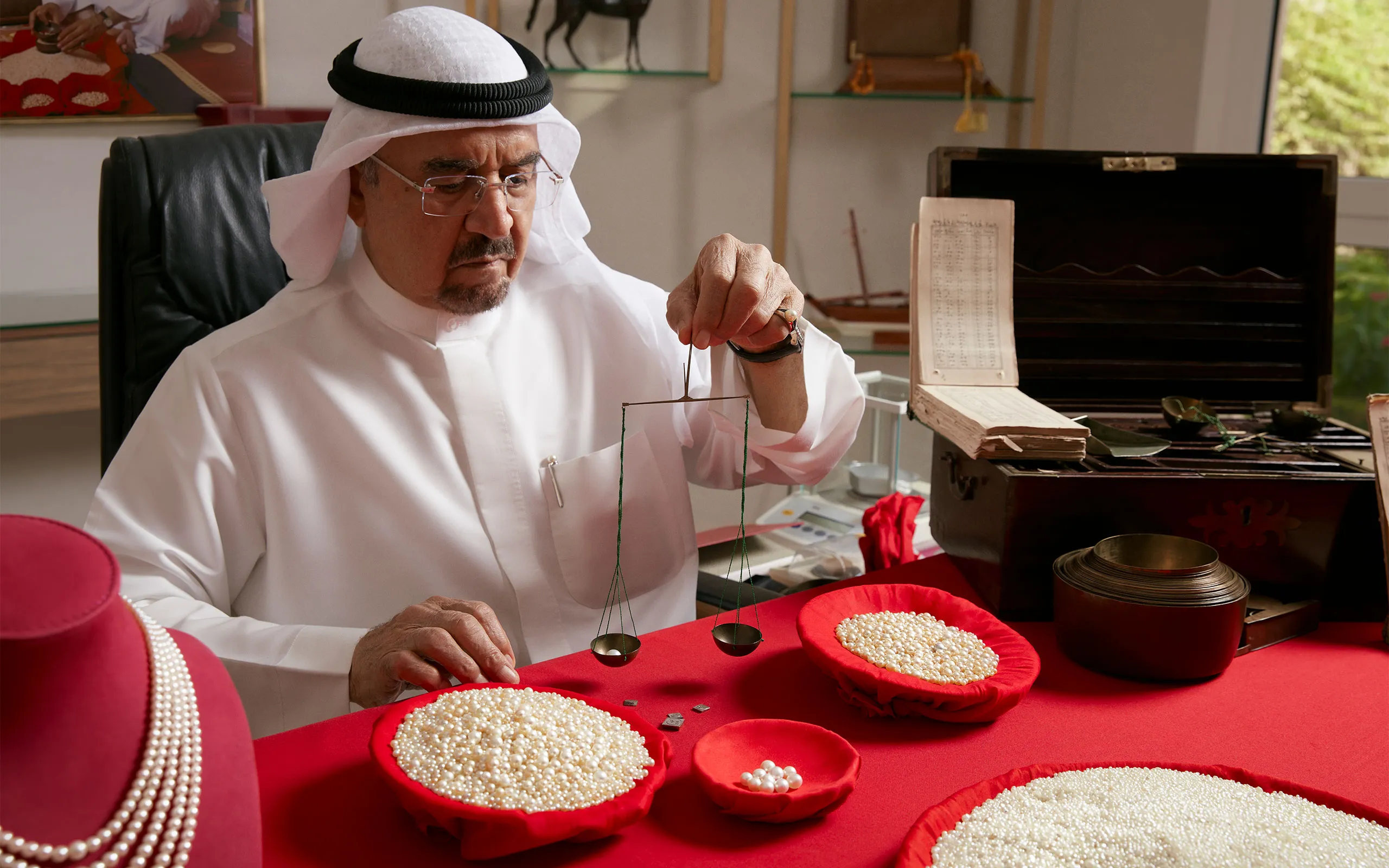 <p>Weighing Al Mahmood’s natural Bahraini pearls the traditional way</p>