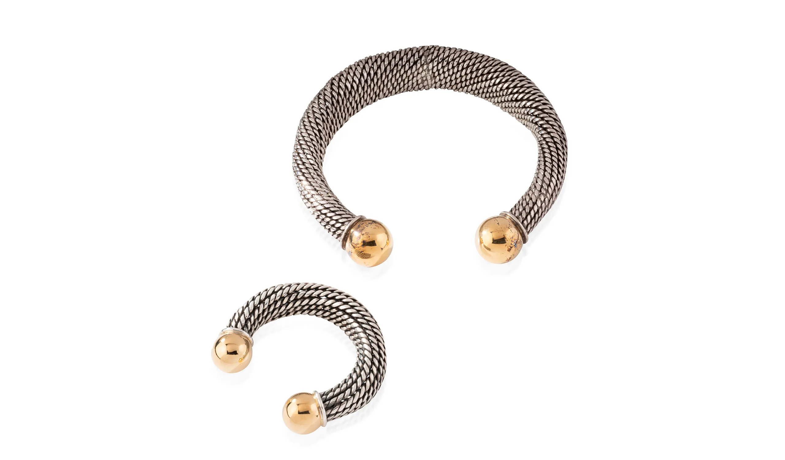 <p>A silver torque necklace featuring two yellow gold ball terminals, designed for René Boivin by Suzanne Belperron circa 1970, and a contemporary bracelet inspired by the original design</p>