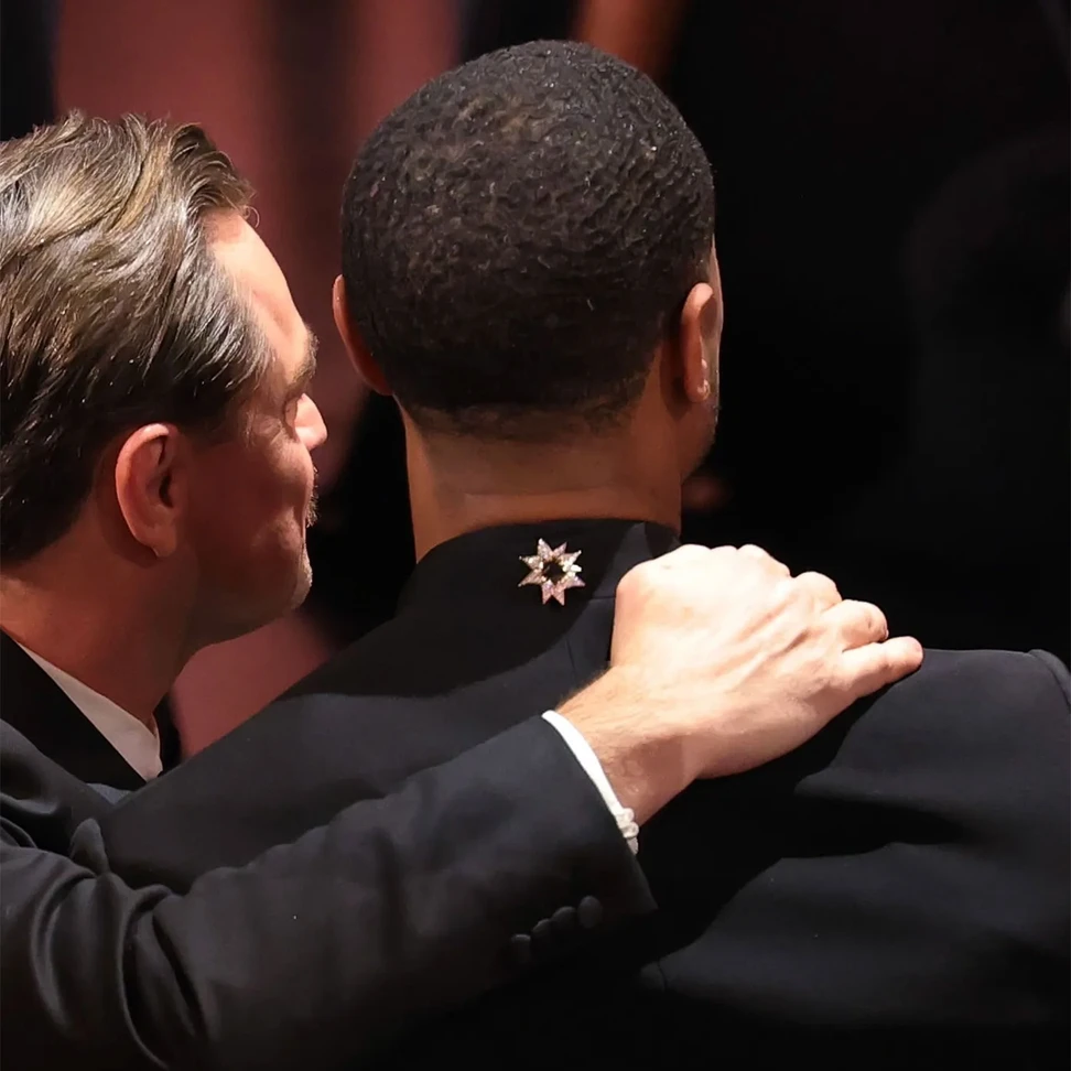 <p>Michael B. Jordan wears a <a href="https://www.davidyurman.com/" target="_blank" rel="noreferrer noopener">David Yurman</a> diamond brooch on the back of his Louis Vuitton jacket</p>