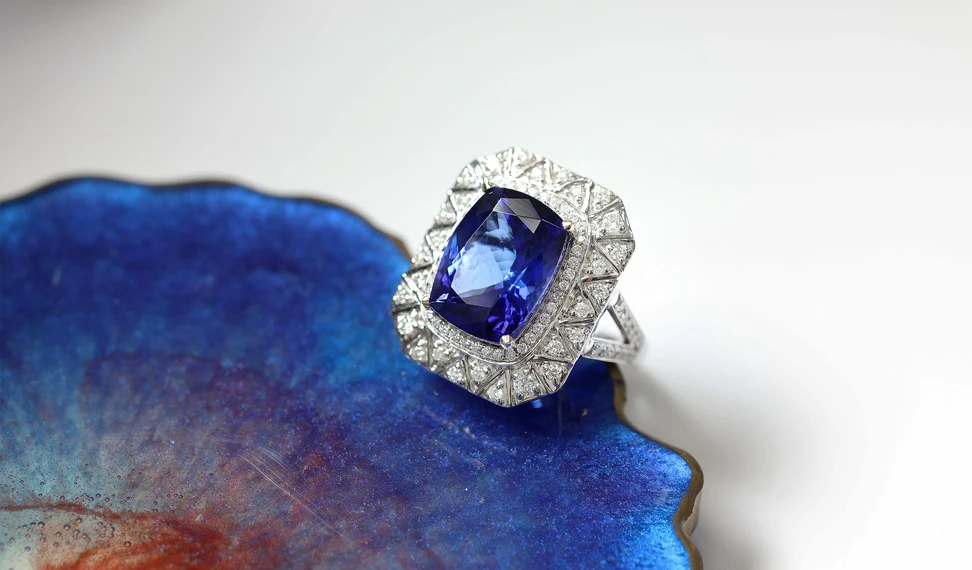 <p>An Art Deco-inspired ring with a central tanzanite surrounded by a geometric layout of white diamonds, crafted by the Royal Touch Group</p>