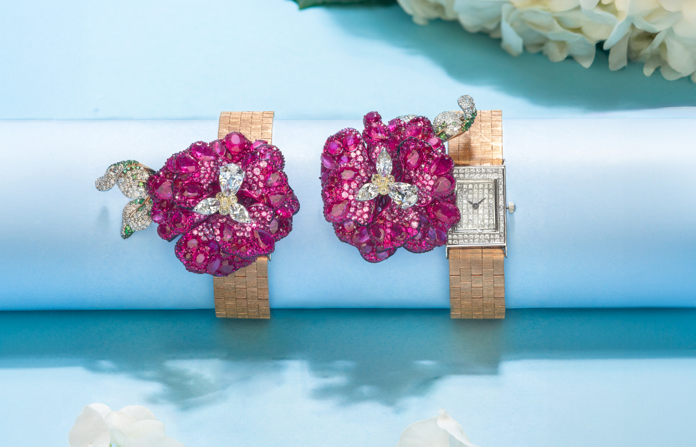 The Diva Jewels Whispering Petals timepiece features a flower bursting with rubies, emeralds and diamonds that swings aside to reveal a diamond-set dial on an 18k gold bracelet strap 