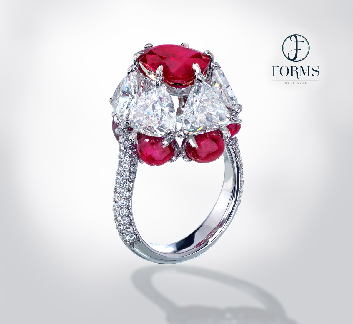 Forms Jewellery, Hong Kong. A ring featuring a 3.85ct ruby from Mogok set with with 6 triangle shaped diamonds each weighing over 1ct and 6 Burmese ruby cabochons over 1ct each