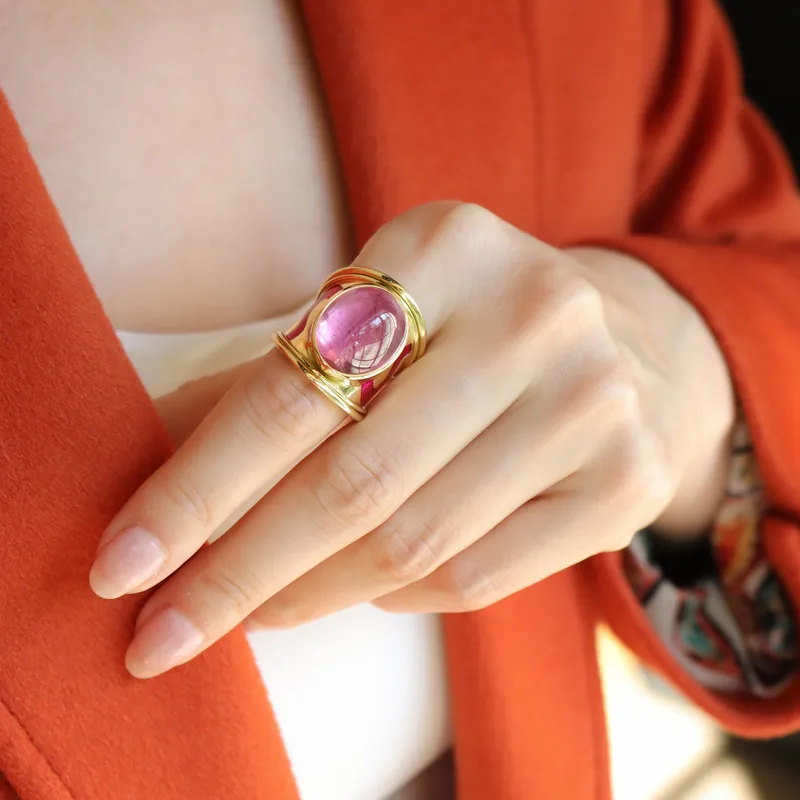 <p>Katerina Perez wears an enamel wave tapered Templar ring by Elizabeth Gage, set with a 17.56 carat fuchsia-coloured pink tourmaline cabochon in 18k yellow gold</p>