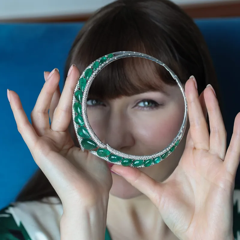 <p>Katerina Perez examines the Stellar Emerald collar necklace by Renu Oberoi, set with 12.5 carats of pavé diamonds and 105 carats of emeralds</p>