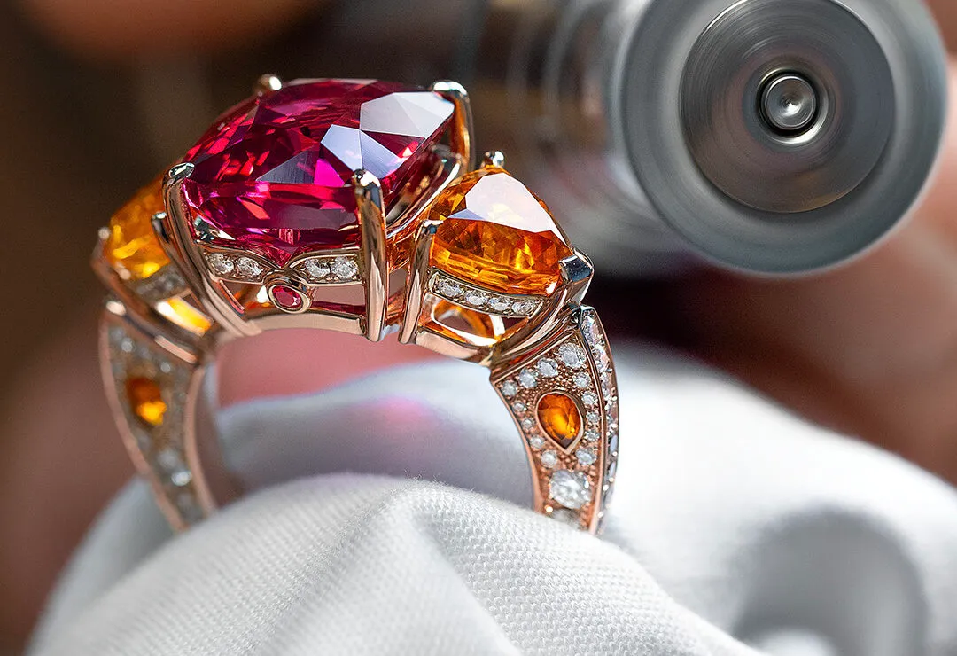 A closer look at the House of Gübelin Classics spinel cocktail ring with a Tanzanian purplish-red spinel of over 9 carats flanked by two mandarin garnets and brilliant-cut diamonds in red gold