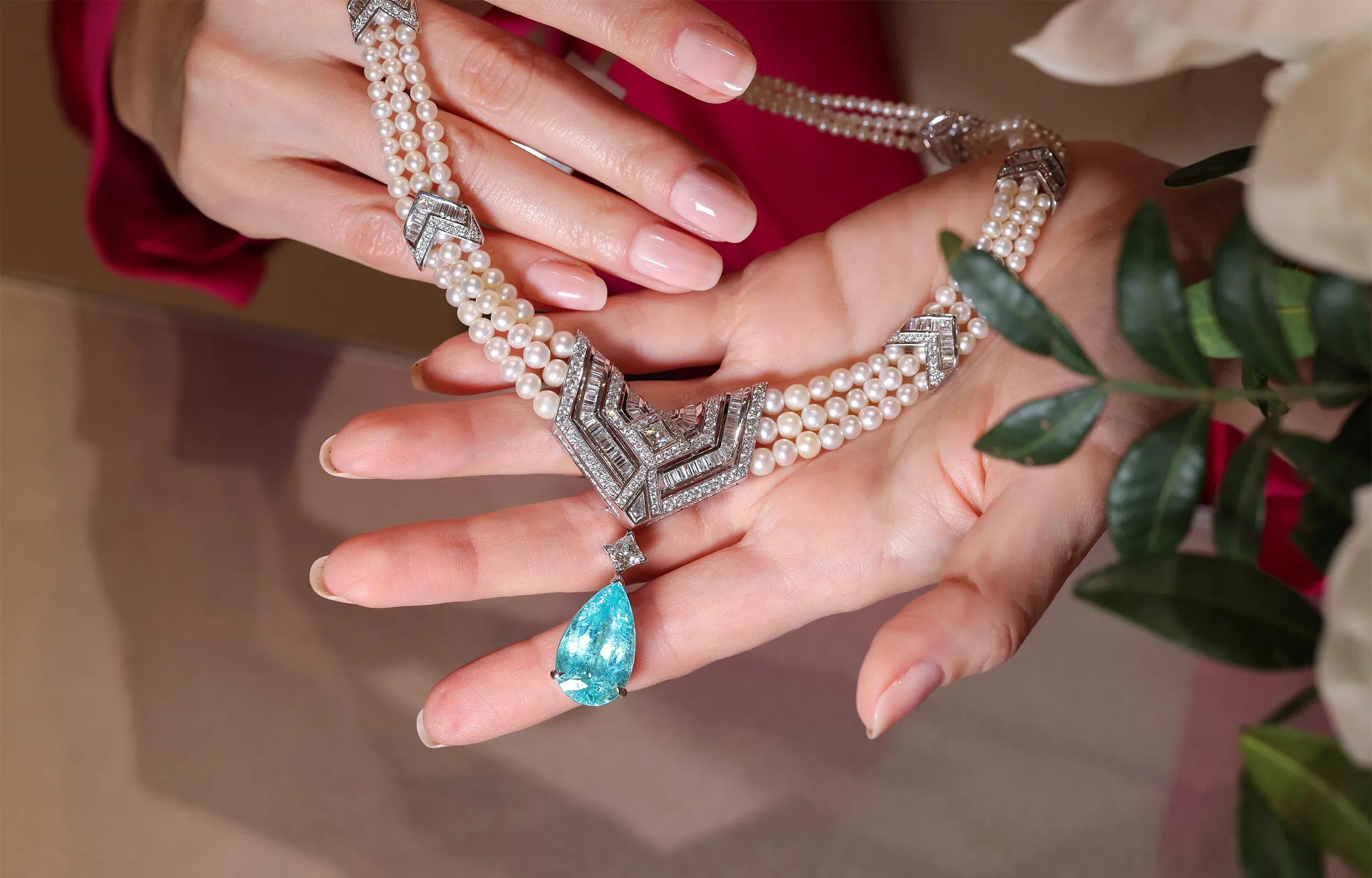 <p>The tropical-sea blue of the Paraiba tourmaline integrates seamlessly into the Arab Deco collection alongside cascading rows of natural Bahraini pearls and sleek rows of baguette cut diamonds</p>