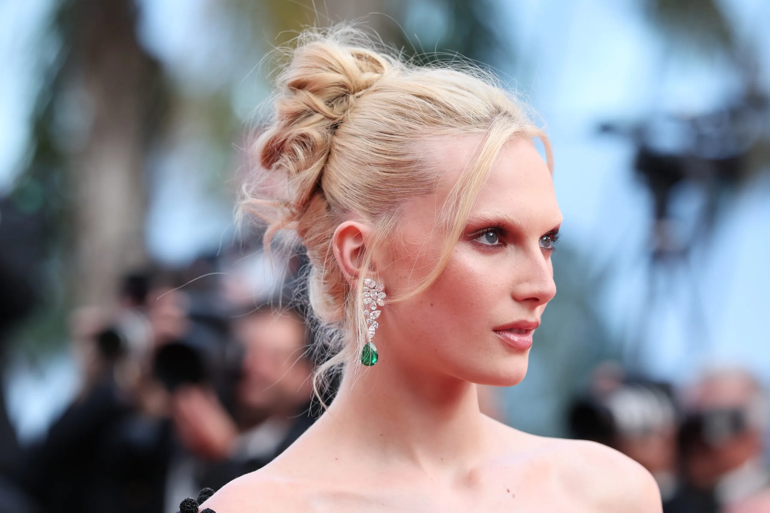 American model and Influencer Alex Consani wears pear-shaped emerald and diamond earrings by Chopard to the Cannes Film Festival 2025