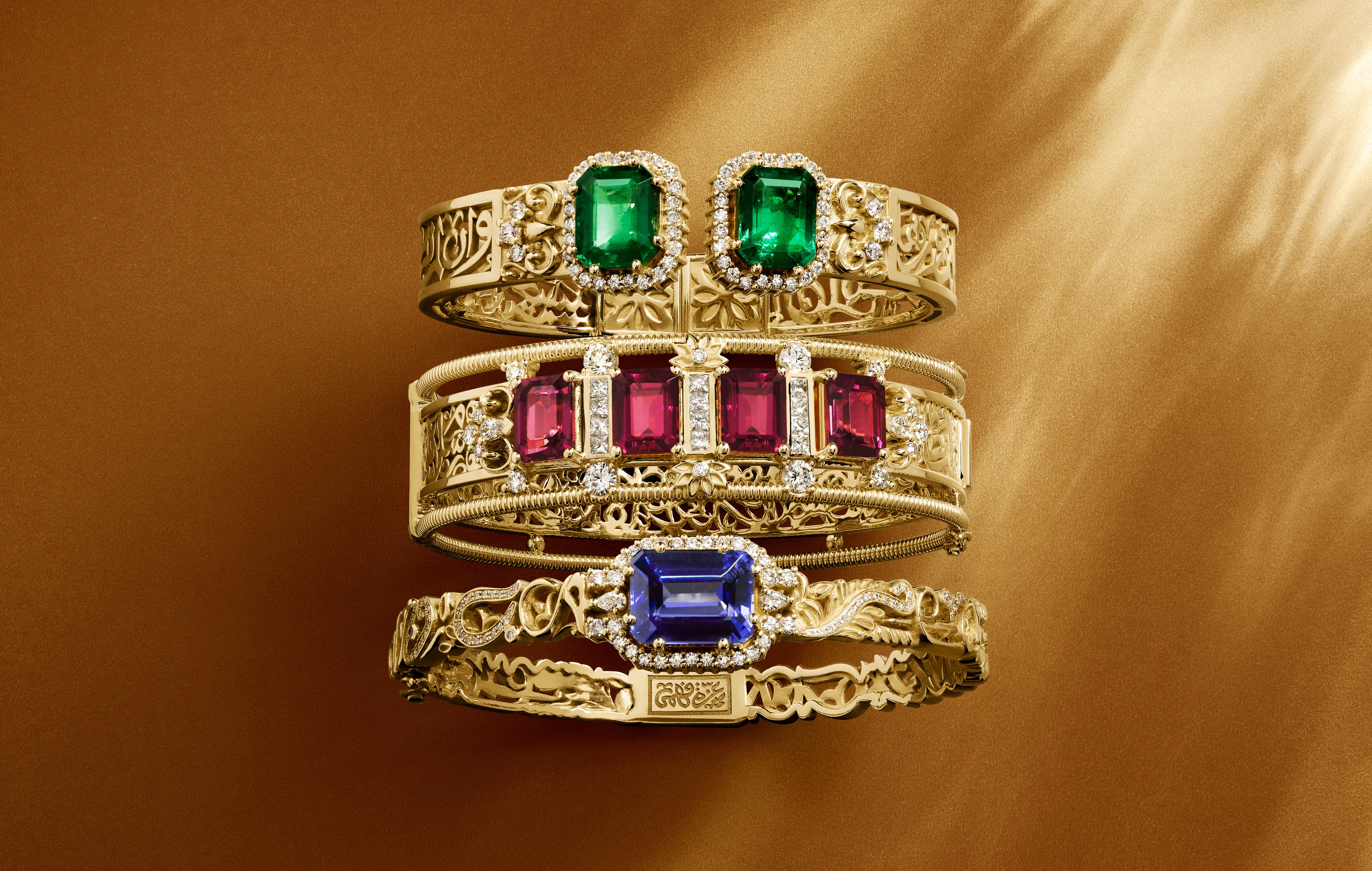 A trio of bangles from the Azza Fahmy Tales of the Nile High Jewellery collection, including the Art Deco Calligraphy bangle (middle) with 11.64-carats of emerald-cut rubellites, diamonds and calligraphy written in openwork yellow gold