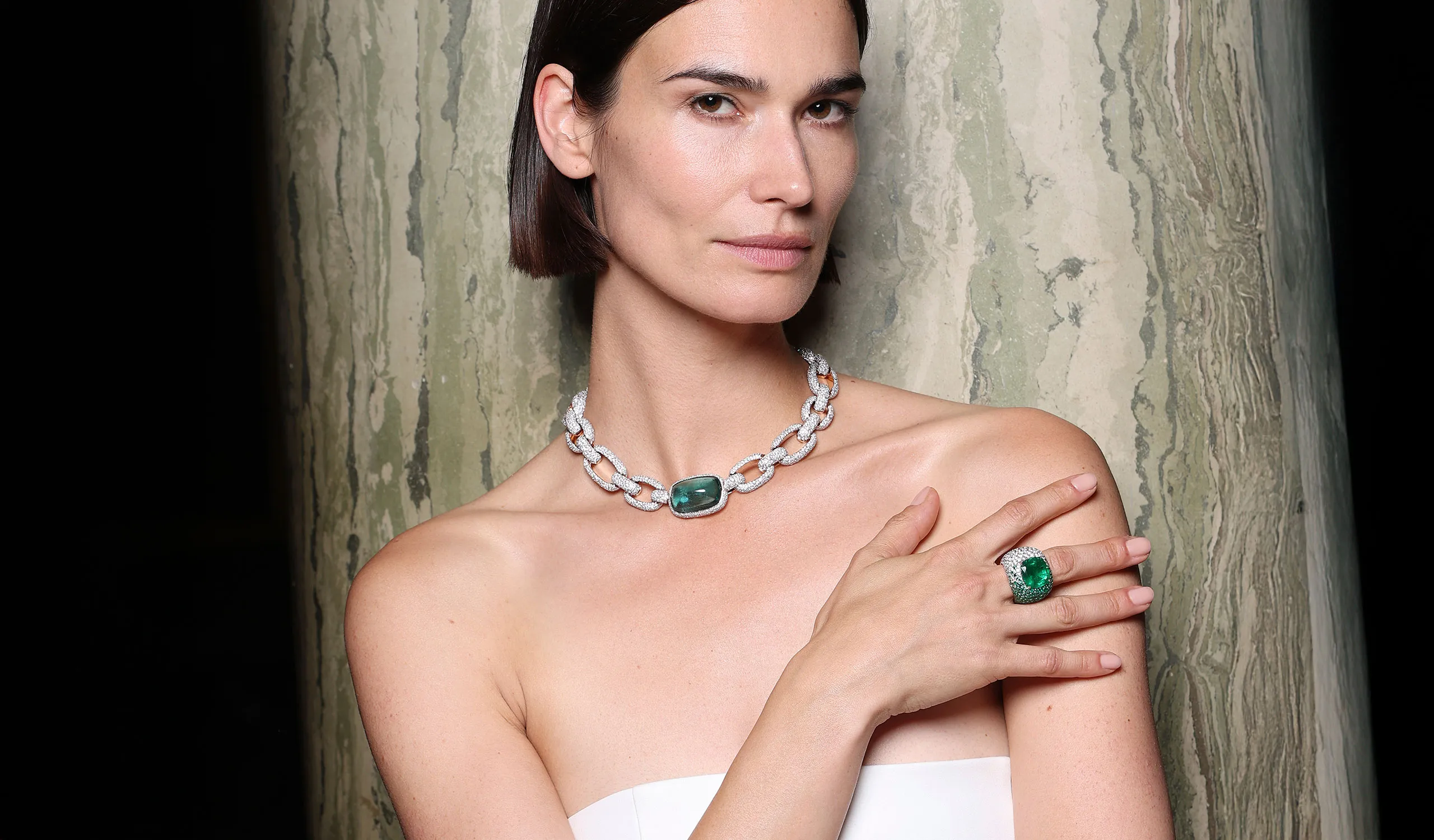A model wears pieces from the Pomellato‘Collezione 1967’ High Jewellery collection, including the Hypnotic Beryl necklace and the Iconica Extreme ring with a 12.27-carat cushion-cut emerald