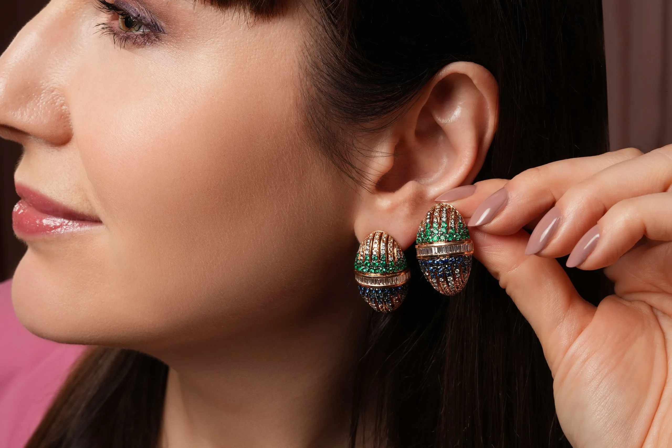 Katerina Perez wears the 'Score of Perspectives' earrings from the Zoya Beyond collection with round-cut emeralds and sapphires and baguette-cut diamonds