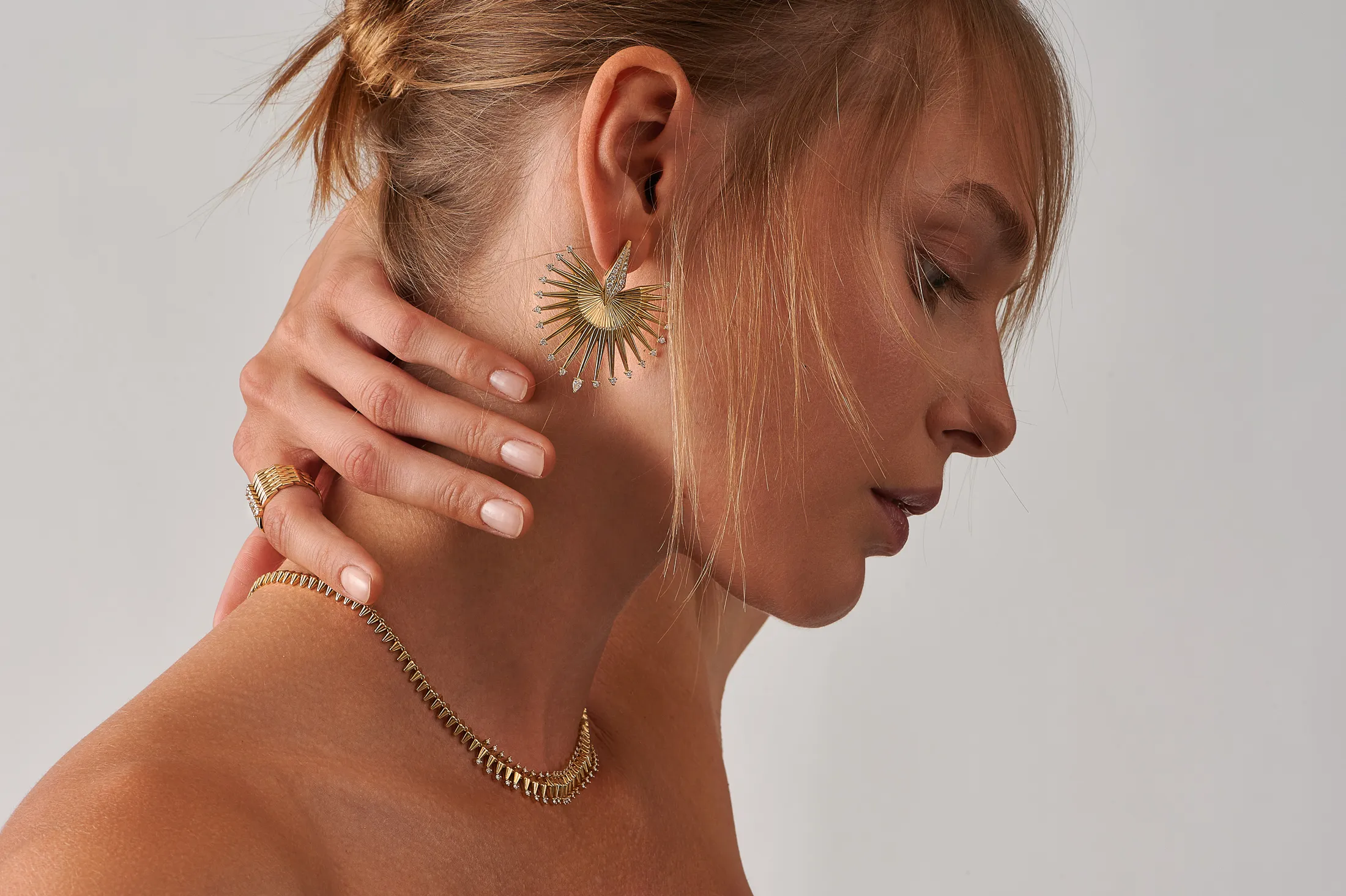 A model wears pieces from the Ariadne collection by Dionysios Fine Jewels set with natural diamonds in 18k yellow gold