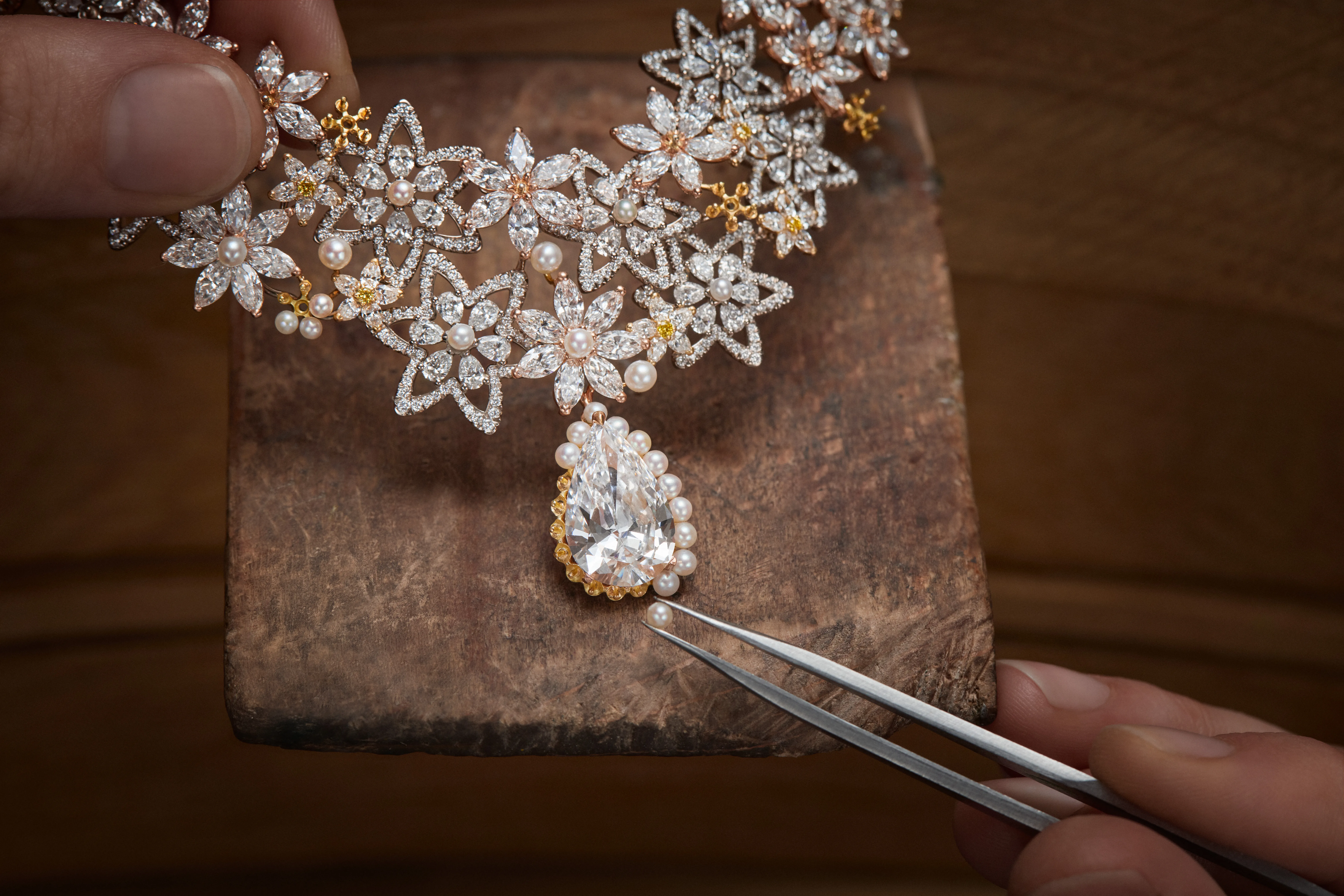 A key necklace from the Dior Milly Dentelle High Jewellery collection is composed of round brilliant-cut and pear-shaped diamond flowers with micro-pearls and a large pear-shaped diamond drop in 18k rose gold 