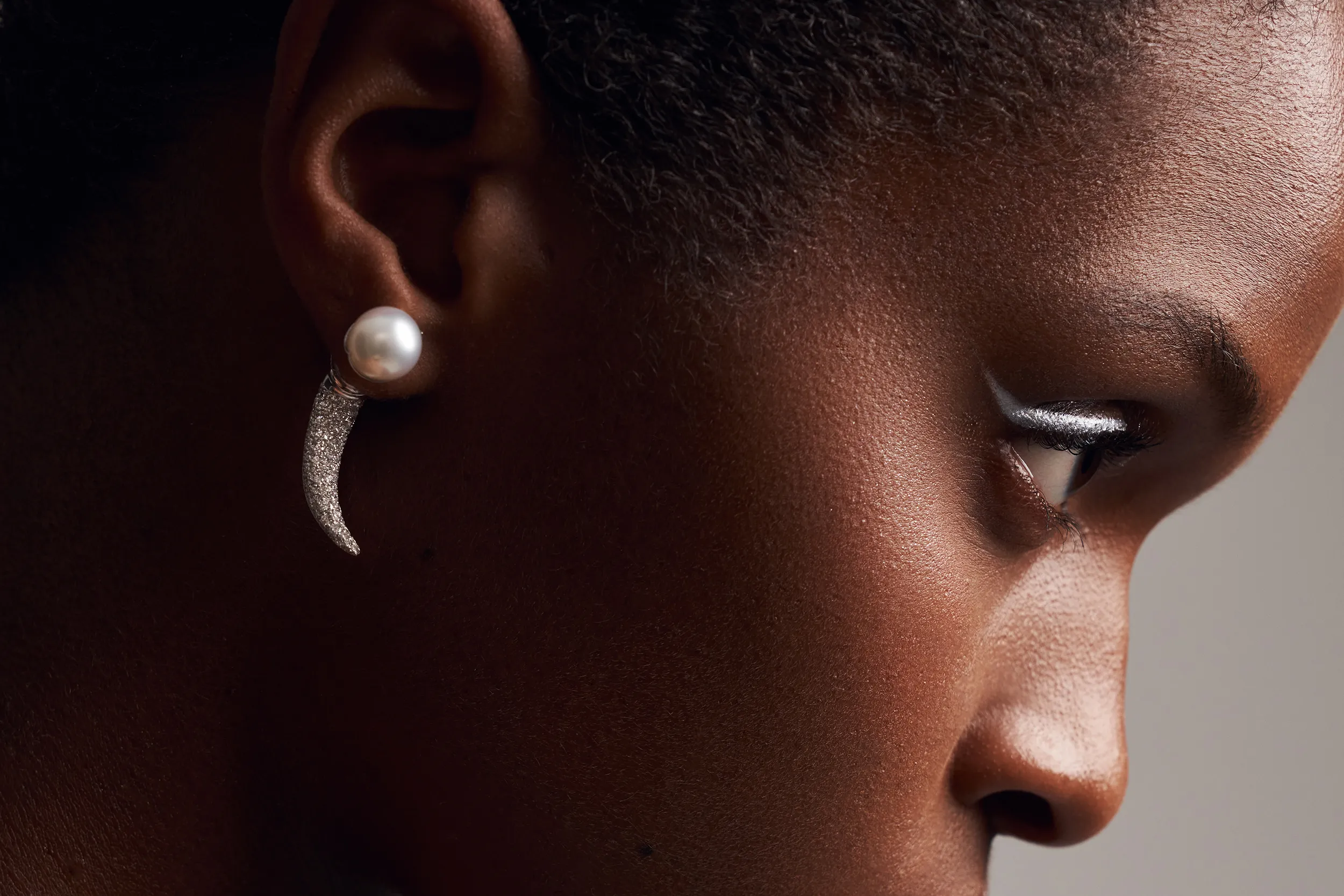 A model wears the El'eeté Jewellery South Sea pearl earrings from Collection №1 with 250 brilliant-cut white diamonds and 10mm pearls set in 18k white gold 