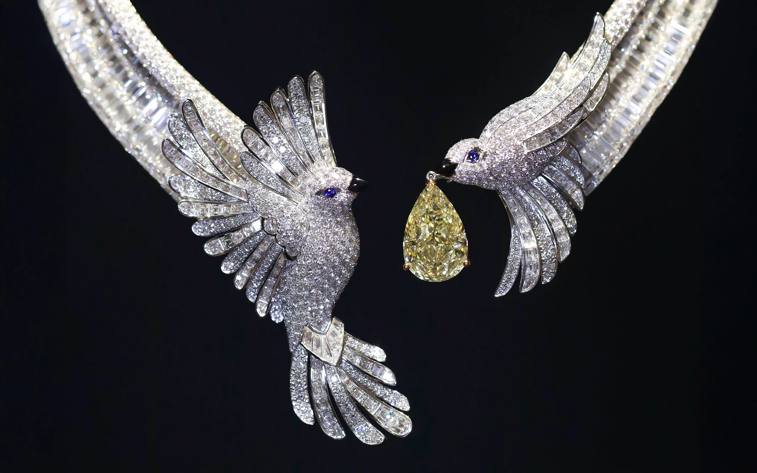 A closer look at the three-dimensional diamond-set sparrows in The Gift of Love necklace by Graff, with one holding a 13.51-carat fancy intense yellow pear-shaped diamond in its onyx beak