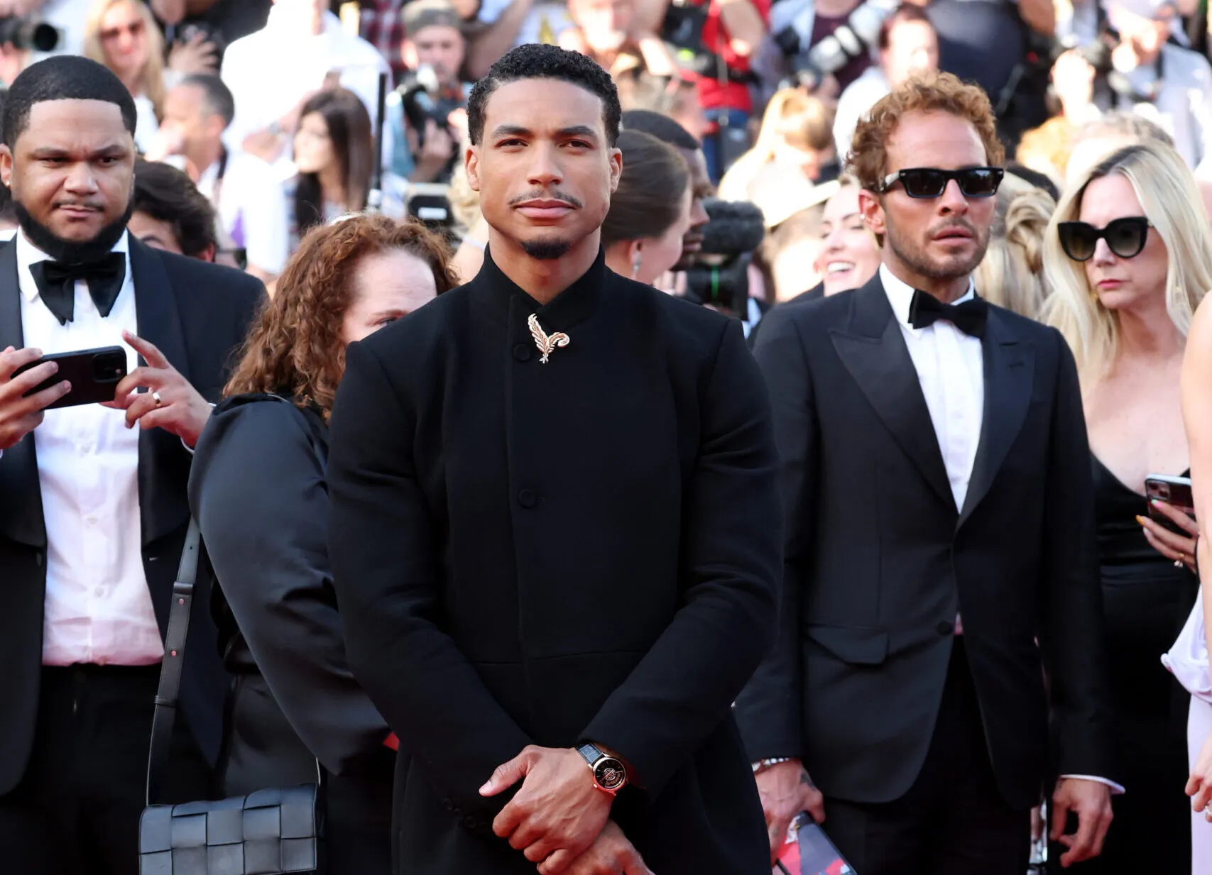 American actor Greg Tarzan Davis adorns his suit with a Chopard feather brooch at the Cannes Film Festival 2025

