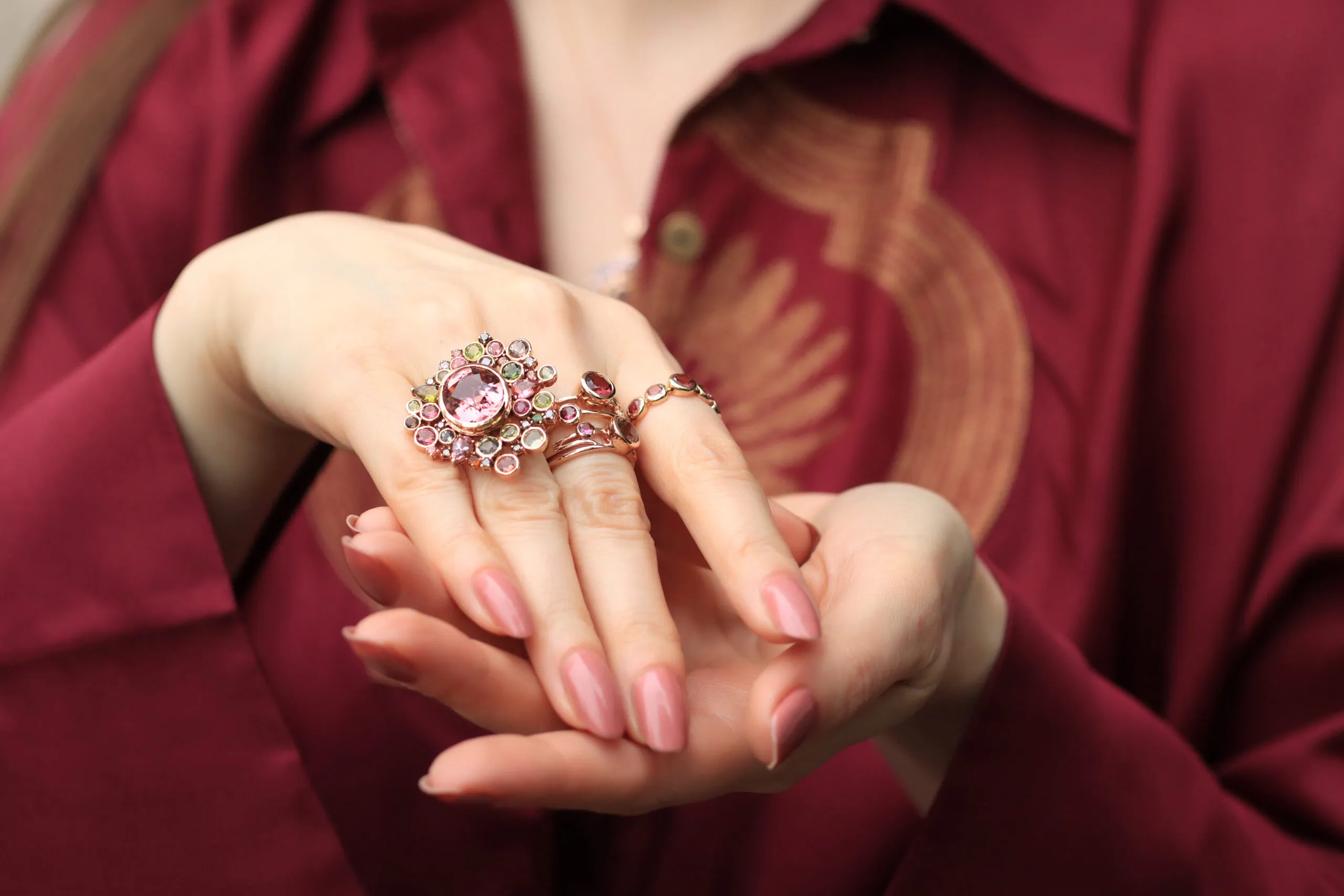 Katerina Perez wears a selection of rings by Zome Jewellery, including the Vera ring from the Anthia collection with a 7.2 carat peach-pink tourmaline and further multi-coloured tourmalines set in 18k rose gold 