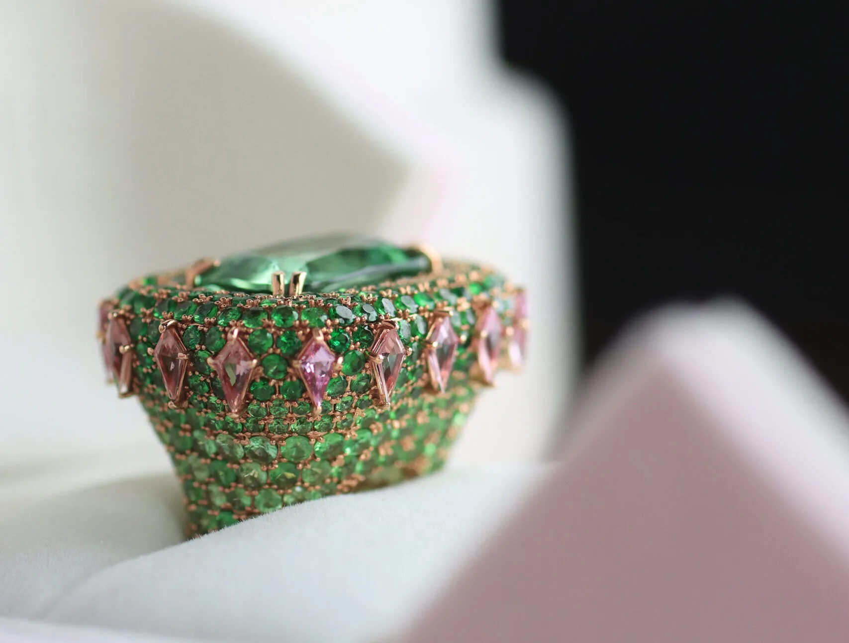 The Zome Jewellery Eterna Verde ring from the Axia collection features 2.31 carats of kite-shaped pink sapphires surrounding 12.37 carats of tsavorites and an 11.63 carat green tourmaline, set in 18k rose gold