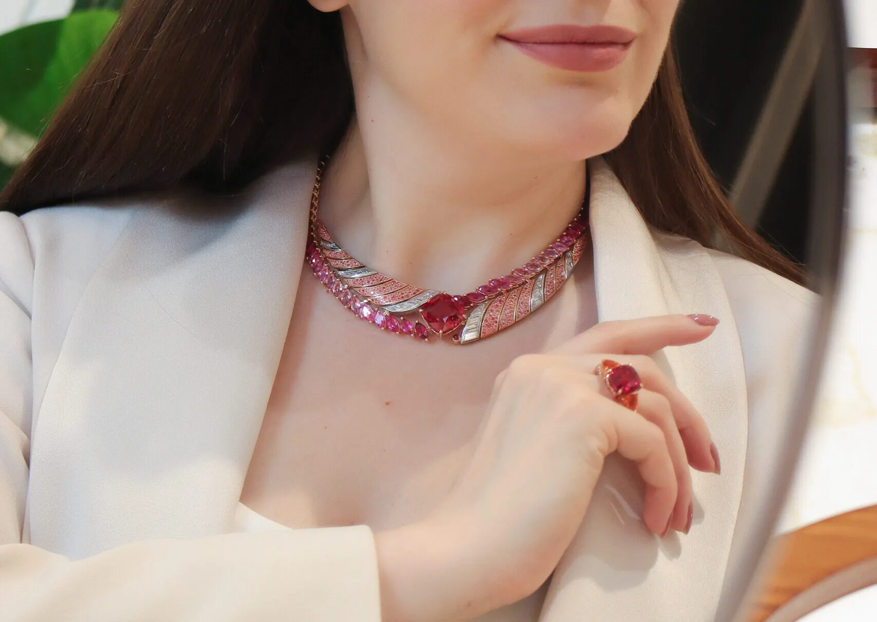 Katerina Perez wears the Tanzanian Sunrise High Jewellery necklace from the House of Gübelin with a 22 carat cushion-shaped red spinel, diamonds, spinels, sapphires and rubies, alongside the Classics cocktail ring with a central spinel, mandarin garnets and diamonds