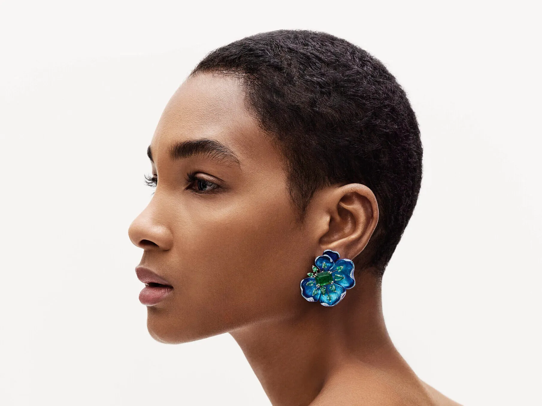 Model wearing floral earrings from Chopard’s Insofu collection, crafted in 18-carat white gold, platinum, and titanium, set with emeralds and brilliant-cut diamonds