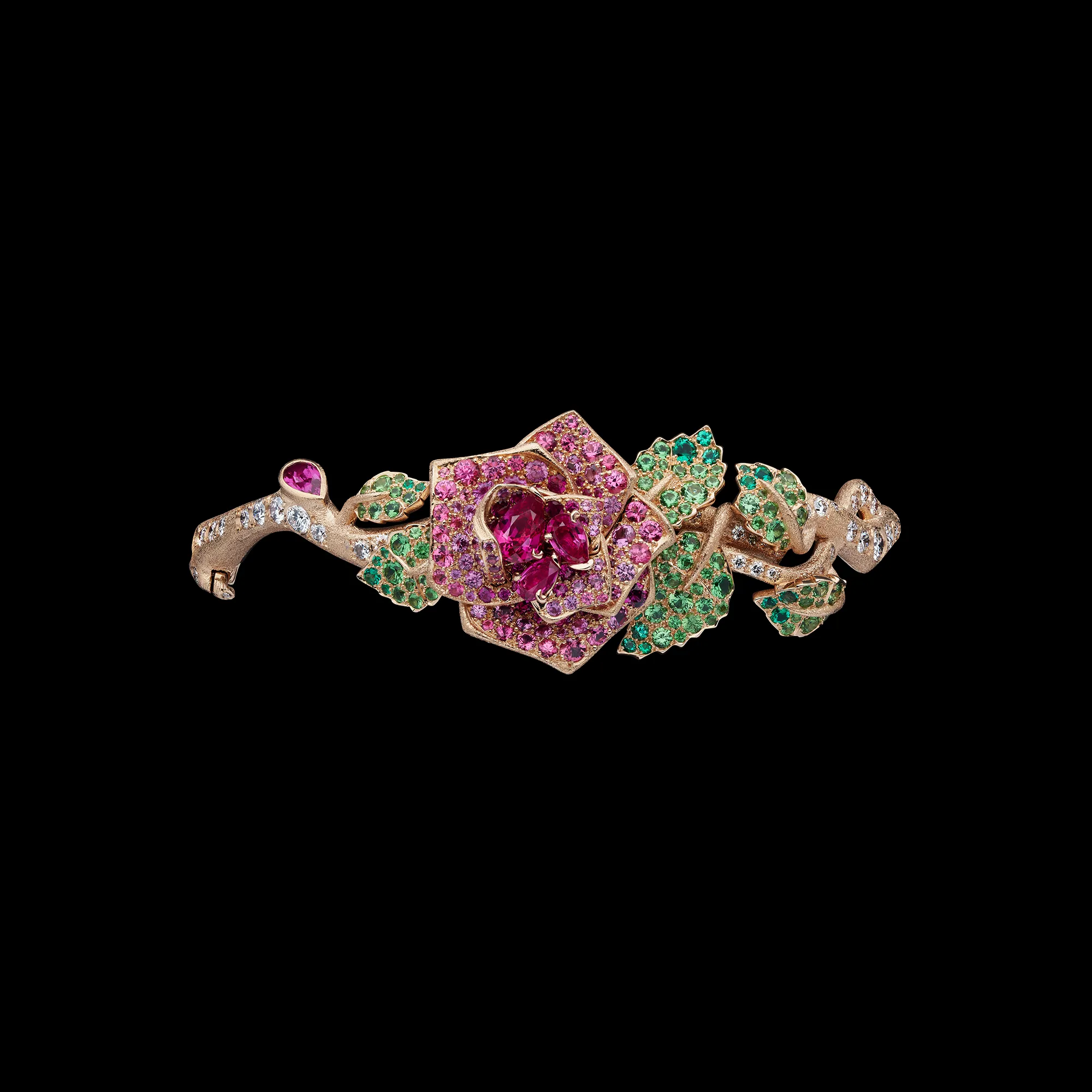 A rose-inspired creation from the Dior Milly Dentelle High Jewellery collection set with emeralds, demantoids, rubies, pink sapphires, and diamonds in textured gold 