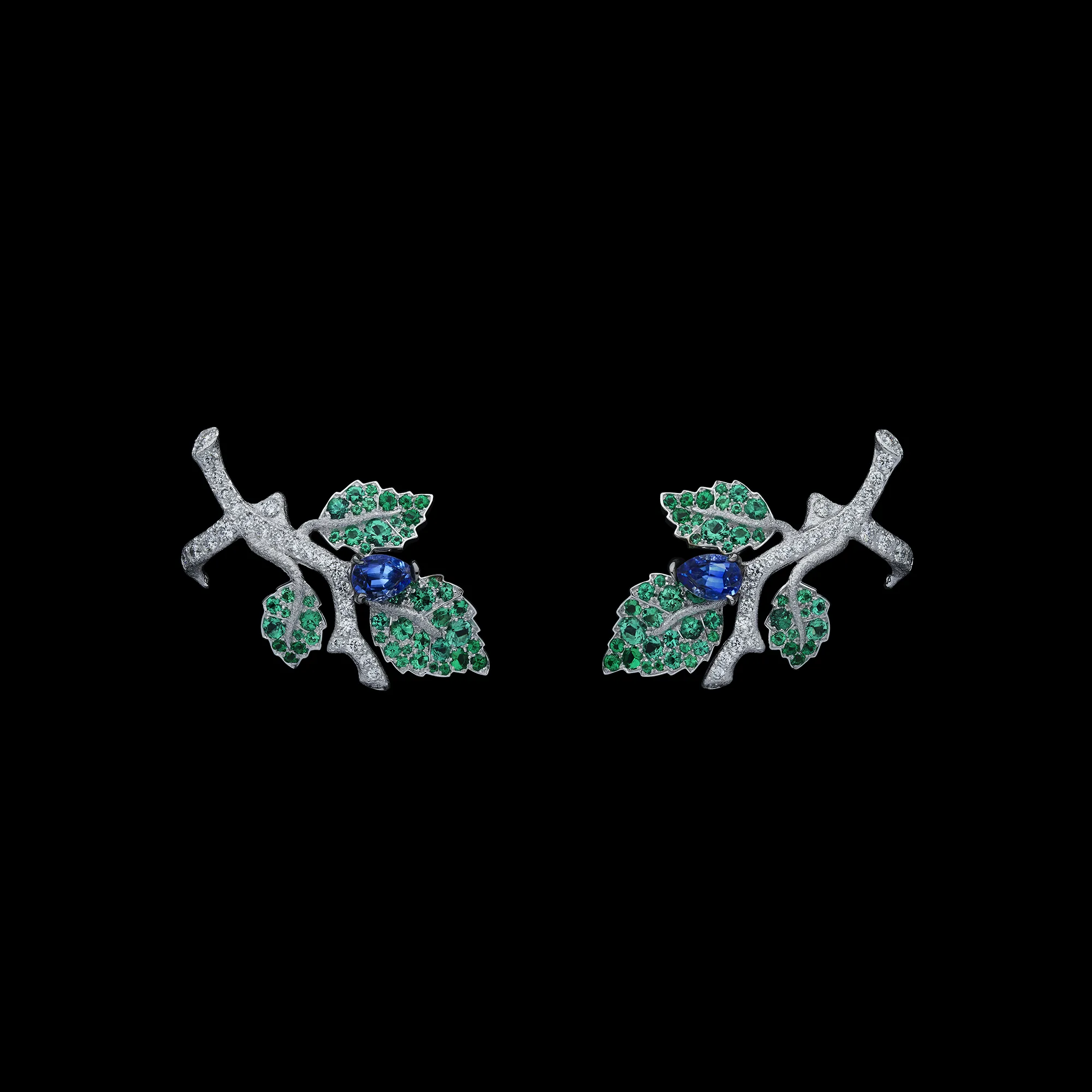 A pair of earrings with oval-shaped sapphires, gem-set leaves and textured white gold branches from the Dior Milly Dentelle High Jewellery collection