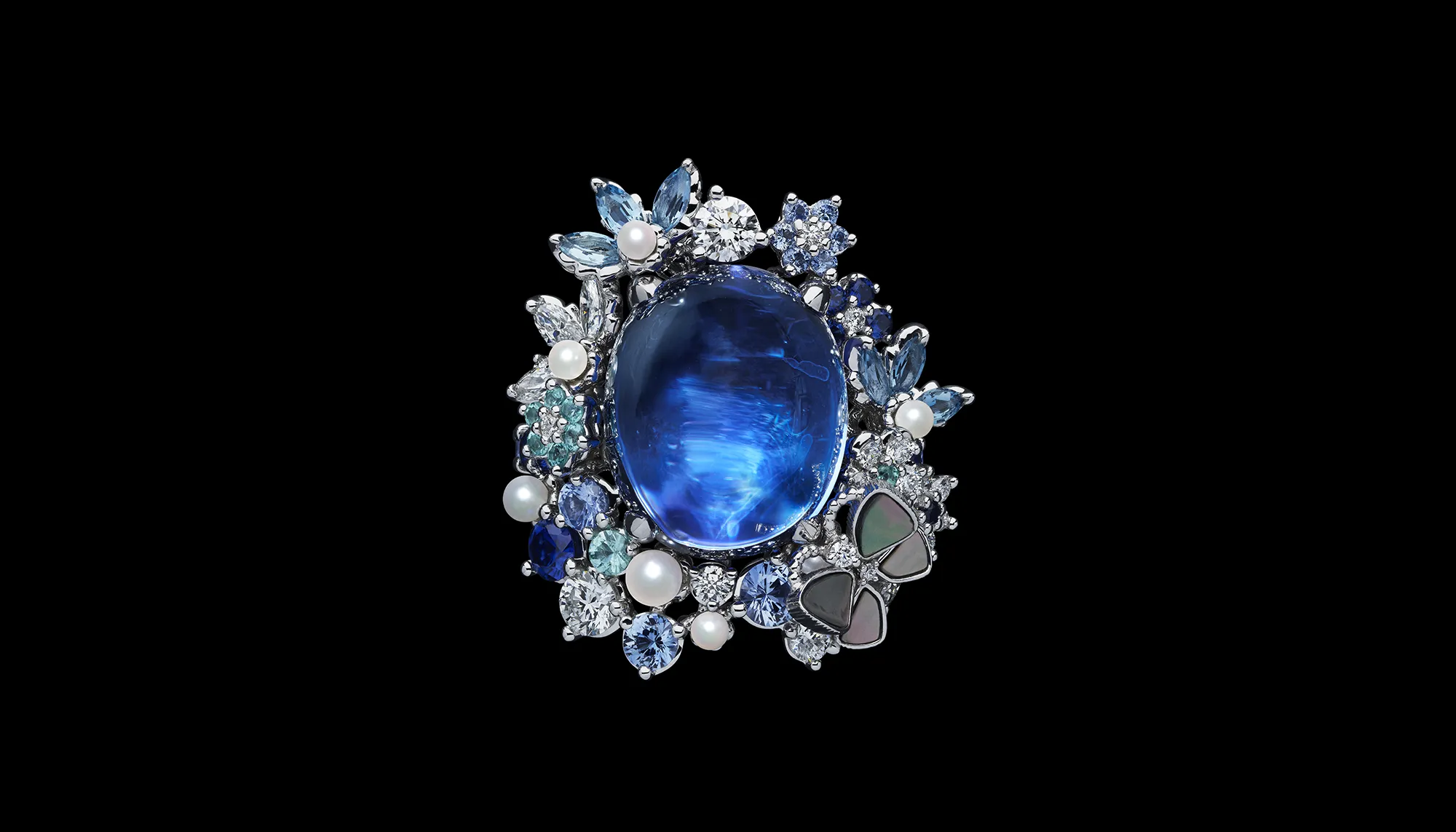 The Dior Milly Dentelle High Jewellery collection features significant gemstones, including this large sapphire cabochon surrounded by micro-pearls, further sapphires, mother of pearl inlay and round brilliant-cut diamonds 