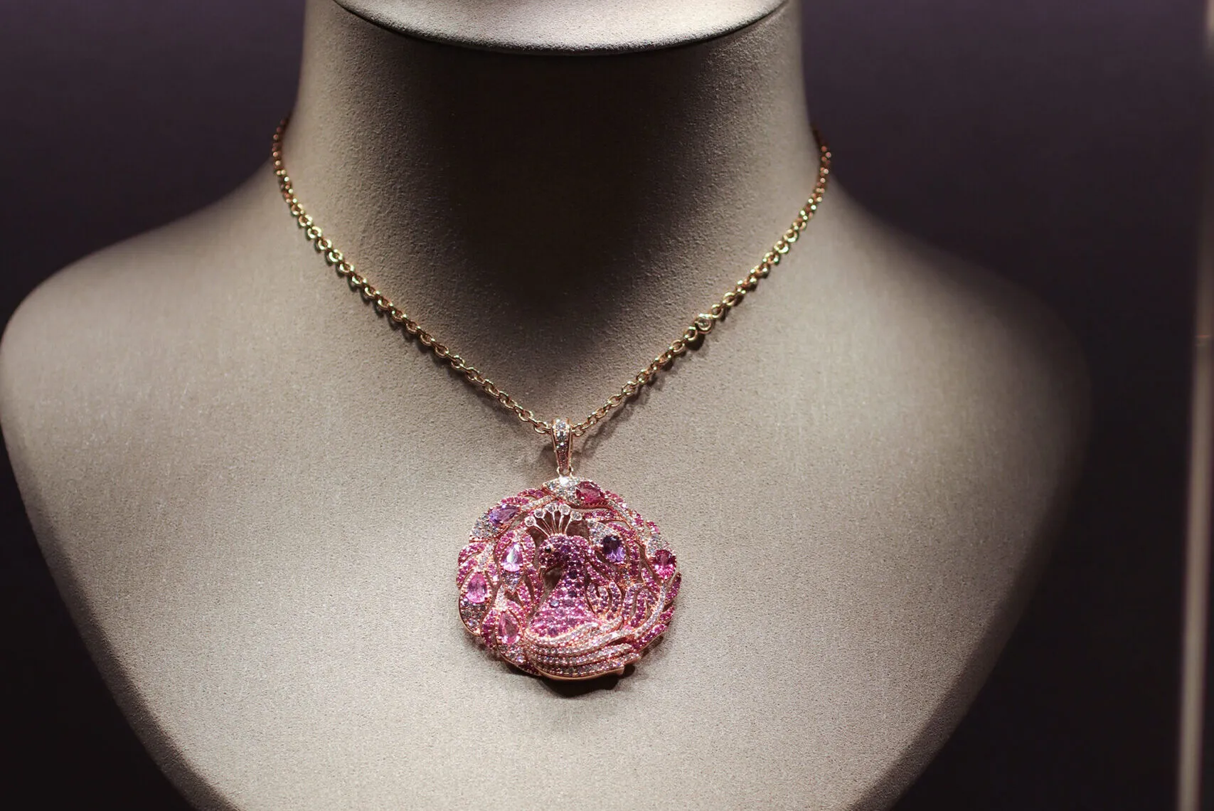 Jaipur Gems peacock-inspired pendant necklace with pink and purple mixed-cut gemstones and diamonds, photographed at the brand's Abu Dhabi boutique
