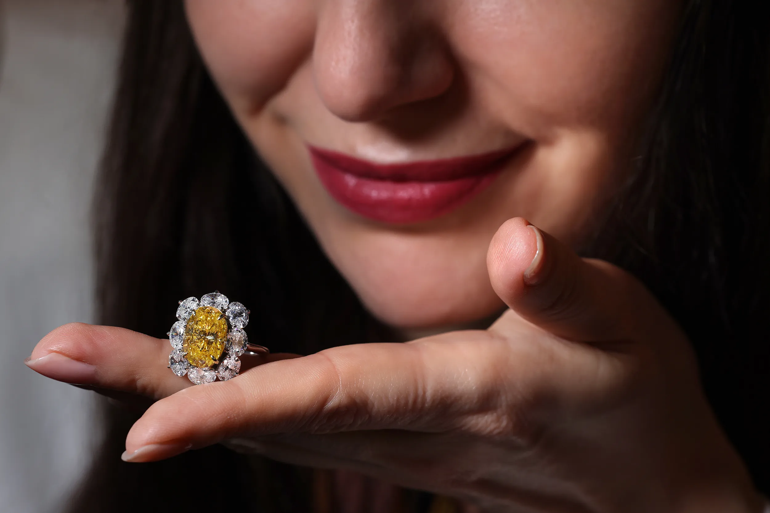 <p>A closer look at the 6 carat Vivid Yellow oval cut diamond cluster ring by Julius Klein with a colourless oval diamond surround</p>