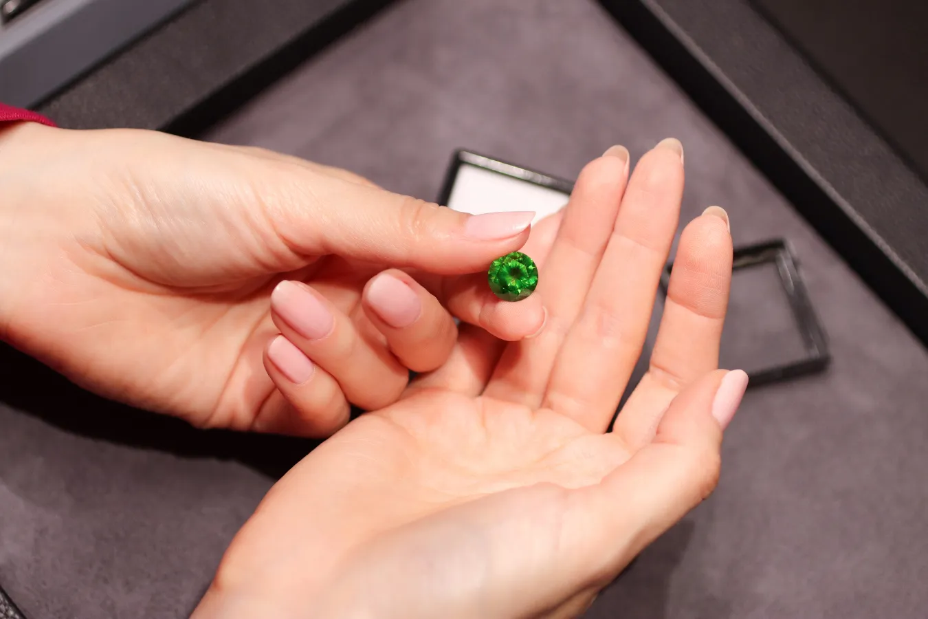 Katerina Perez holds a round-cut Russian demantoid garnet supplied by Tsarina Jewels