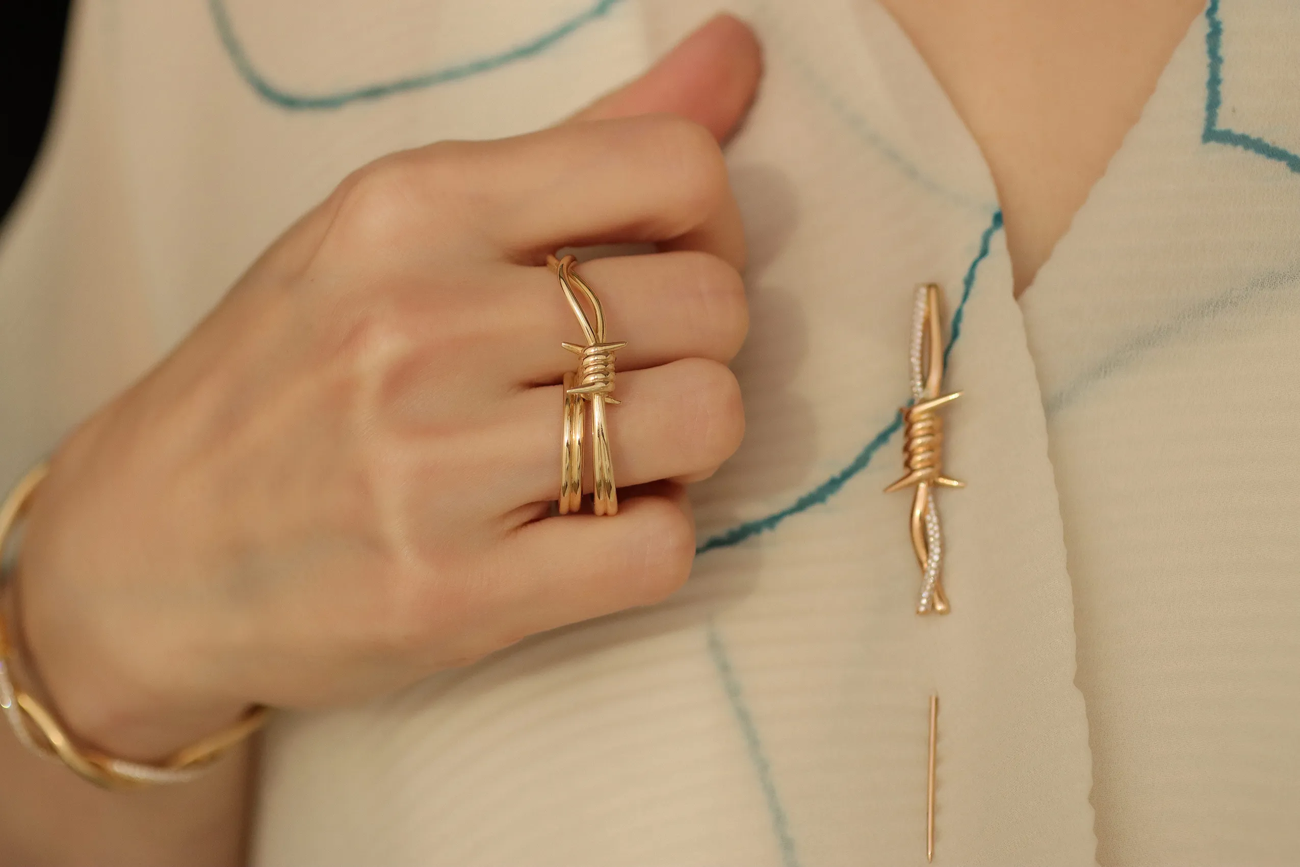 <p>A brooch and two-finger ring in 18k yellow gold with diamonds from Moody Jewellery&#8217;s Wethaq collection</p>
