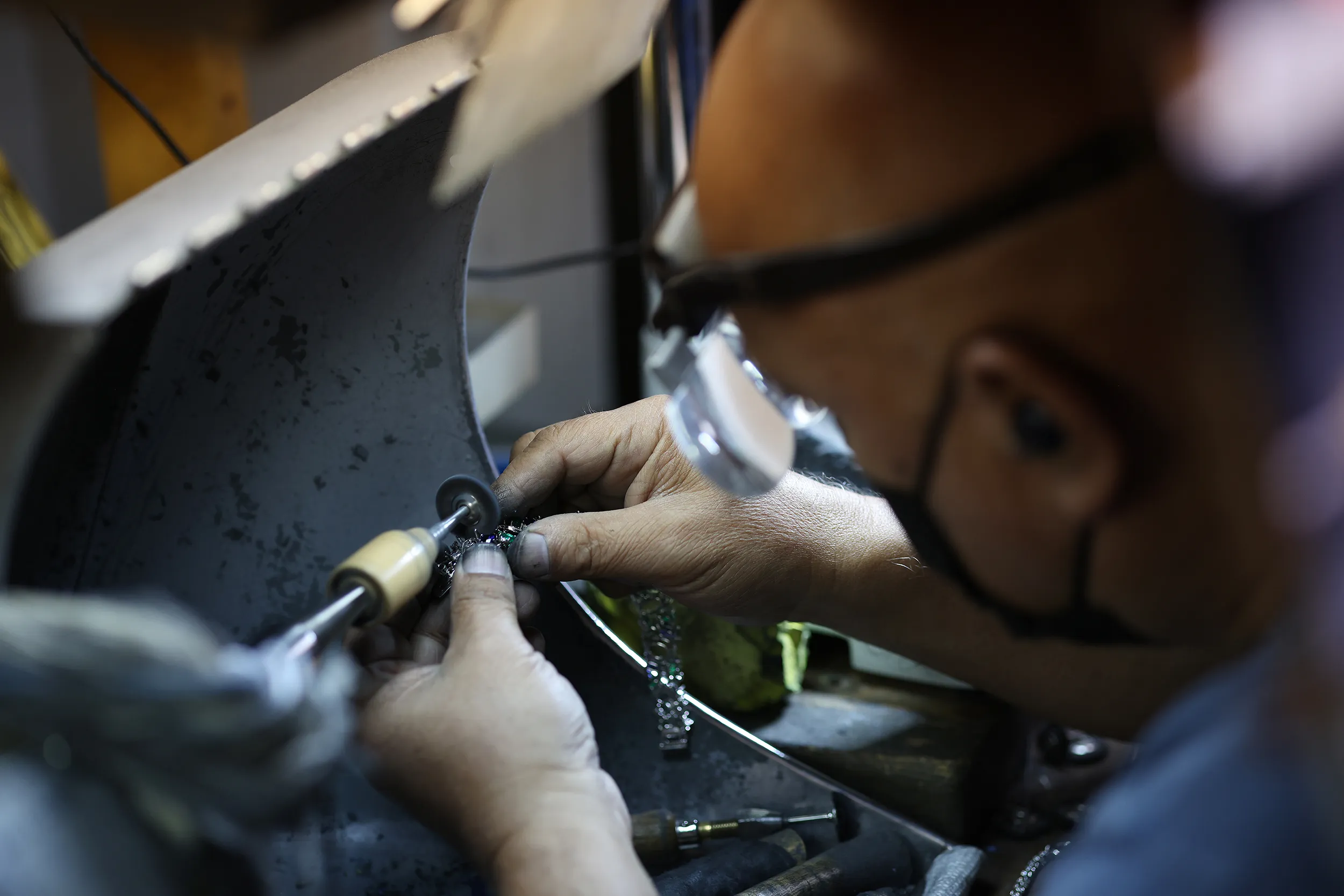 <p>Settings for an in-process bracelet are polished before Australian black opals are added to a mix of emeralds, sapphires and diamonds</p>
