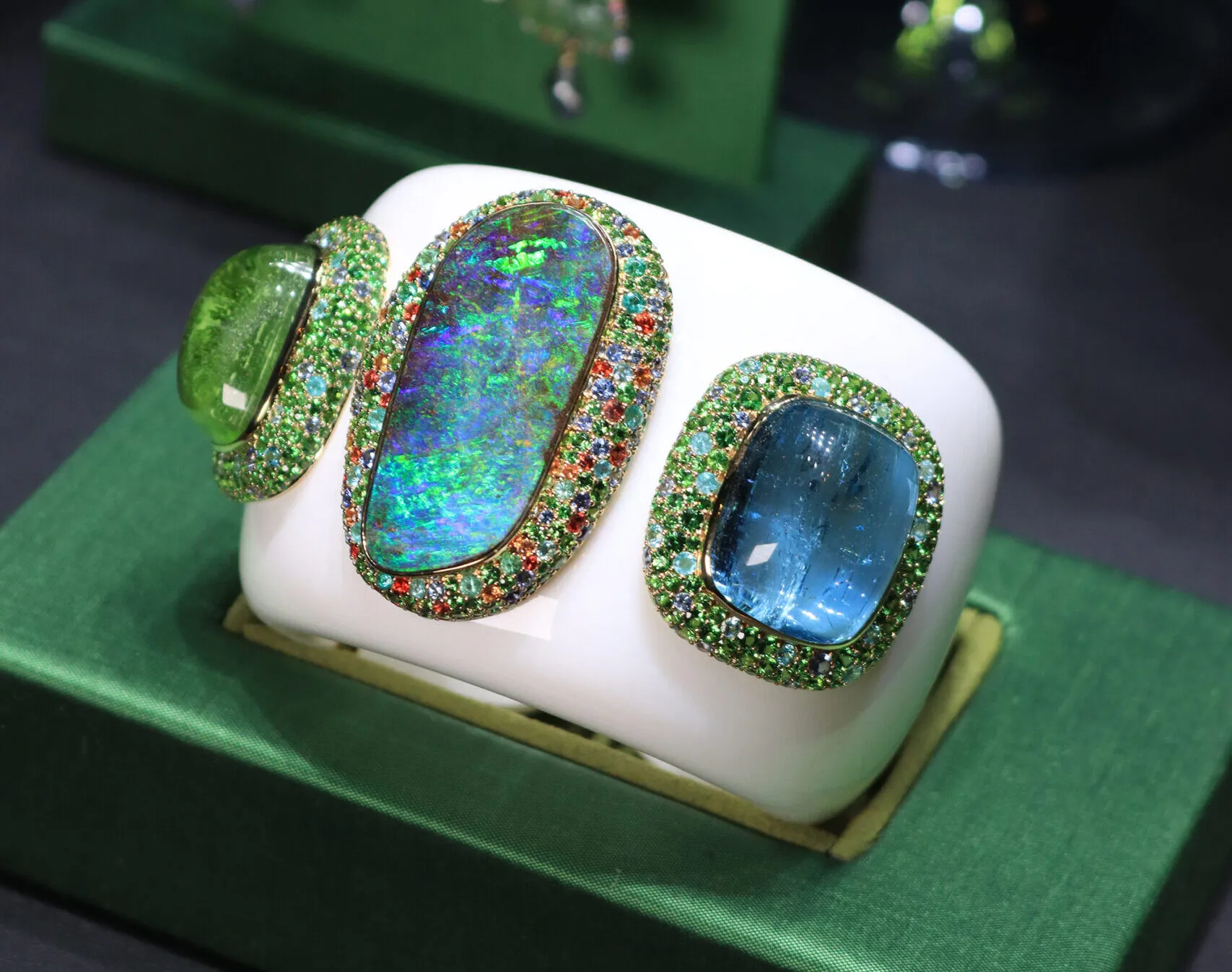 Margot McKinney Lagoon cuff with a 54.25 carat Australian boulder opal, a 64.35 carat aquamarine, and a 78.28 carat peridot surrounded by white opal, blue sapphires, orange sapphires, Paraiba tourmalines, and tsavorites, set in 18k white and yellow gold 