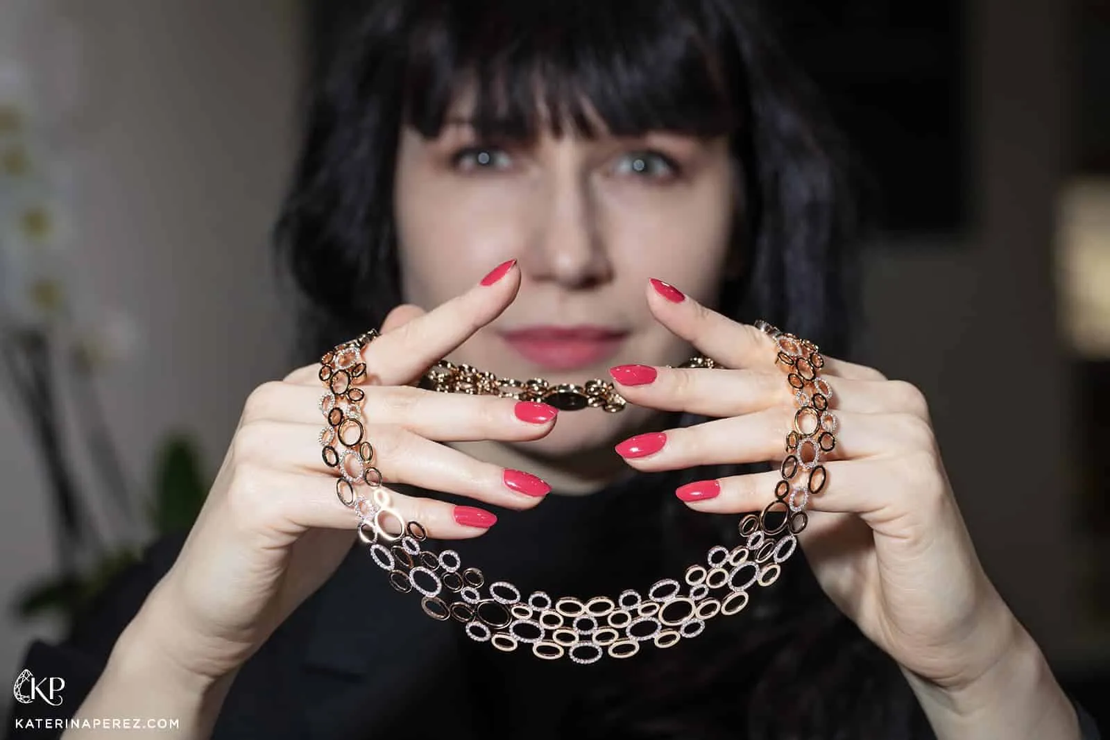 Katerina Perez holds the Leo Wittwer Panta Rhei necklace crafted in gold with diamonds