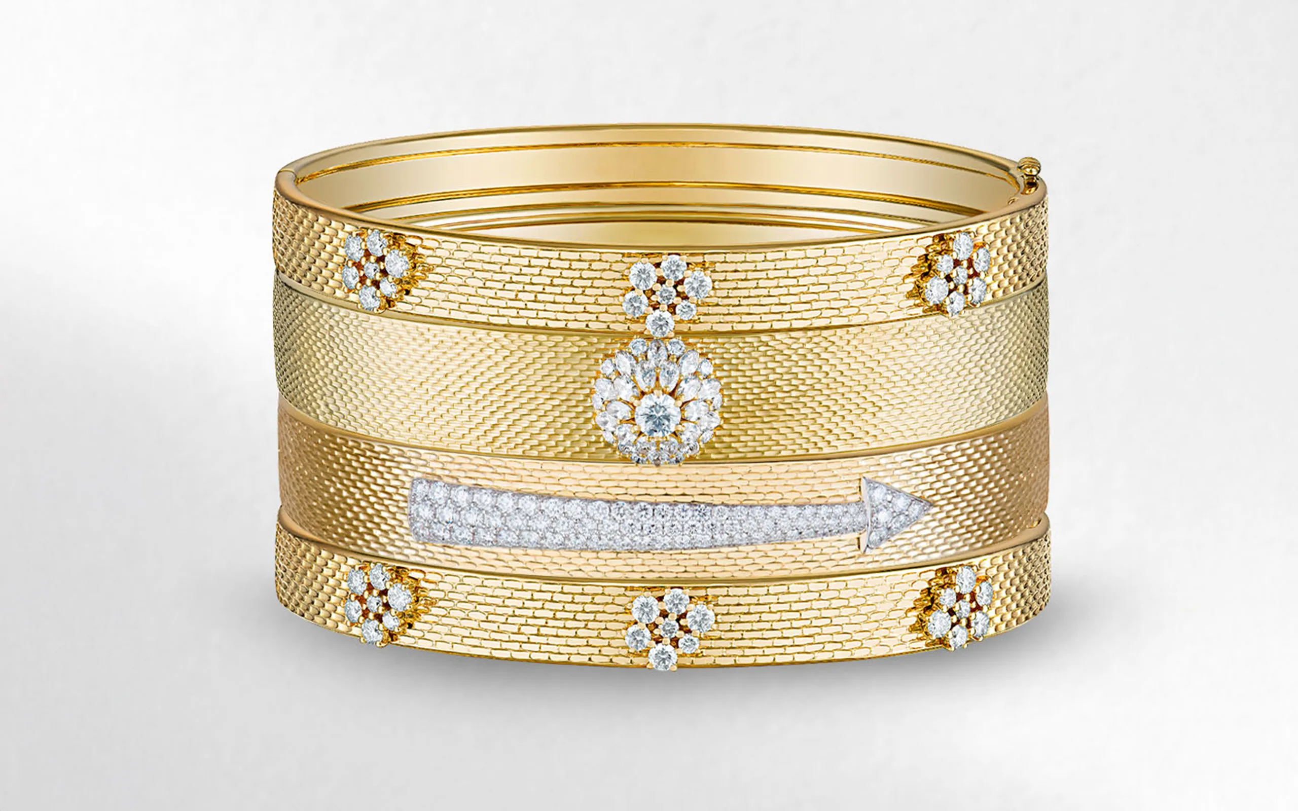 Stackable bangles from the Seven Sisters collection by Marceline Paris, including the Pleiades Diamond bangle (top and bottom) in 18k yellow gold 