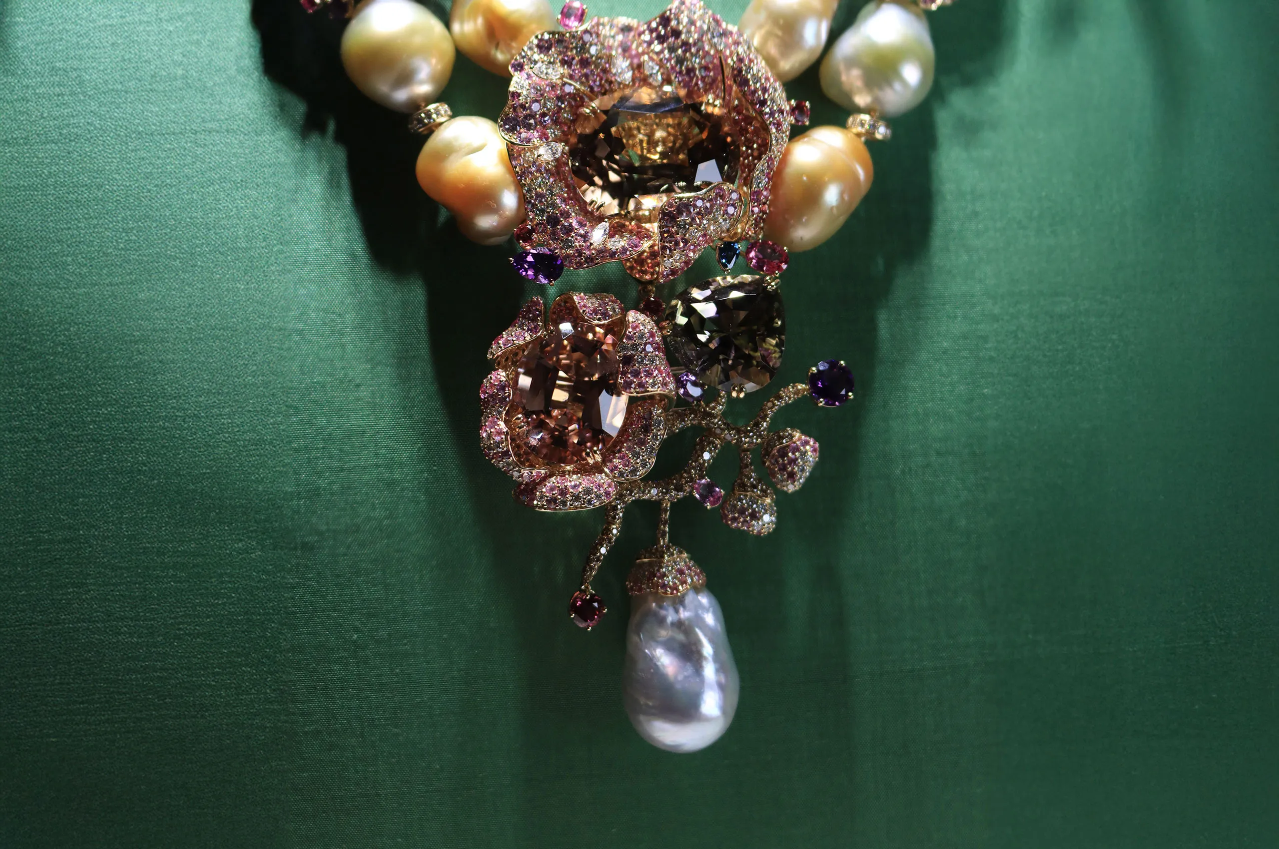 The focal point of the Margot McKinney Bloem collier with a 65.85 carat tourmaline, Australian South Sea baroque pearls, and a mixture of white diamonds, brown diamonds, blue, pink and purple sapphires, pink tourmalines, amethysts and rubellites, set in 18k yellow gold 