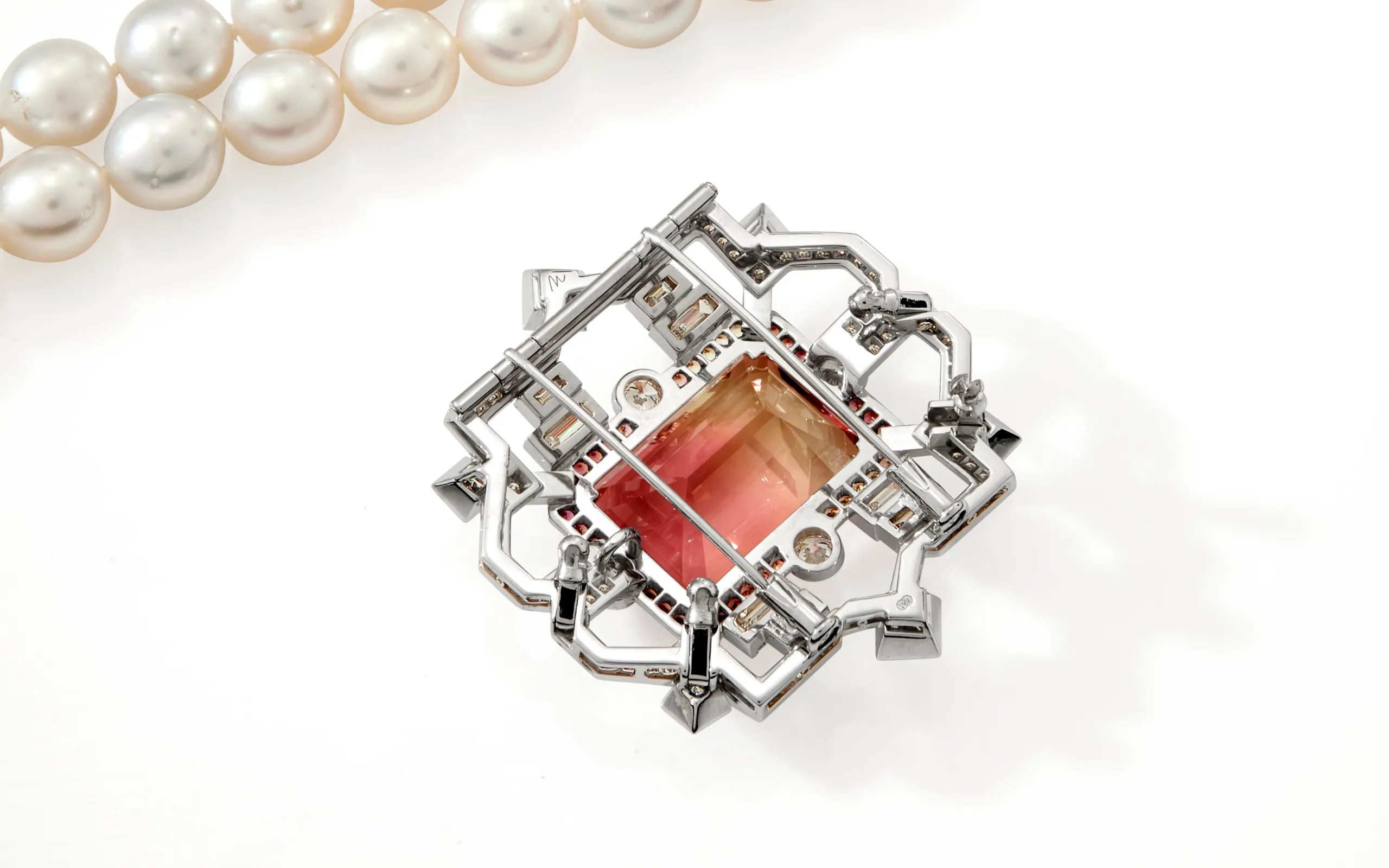 The reverse side of an Art Deco-inspired brooch-pendant by Matthew Ely, set with a 24.34 carat bi-colour tourmaline, sapphires and diamonds in 18k white gold 