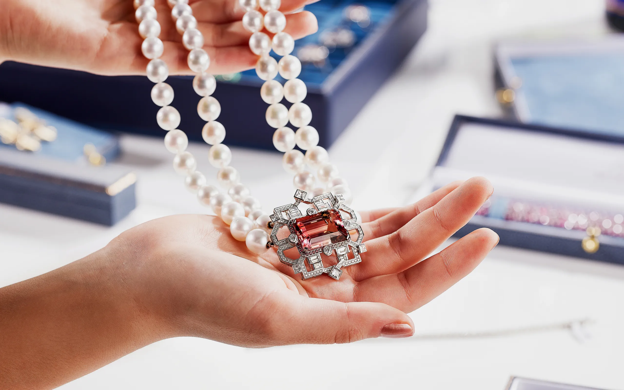 A transformable brooch-pendant by Matthew Ely, featuring a 24.34 carat bi-colour tourmaline surrounded by colour fade sapphires and diamonds, crafted in 18k white gold 