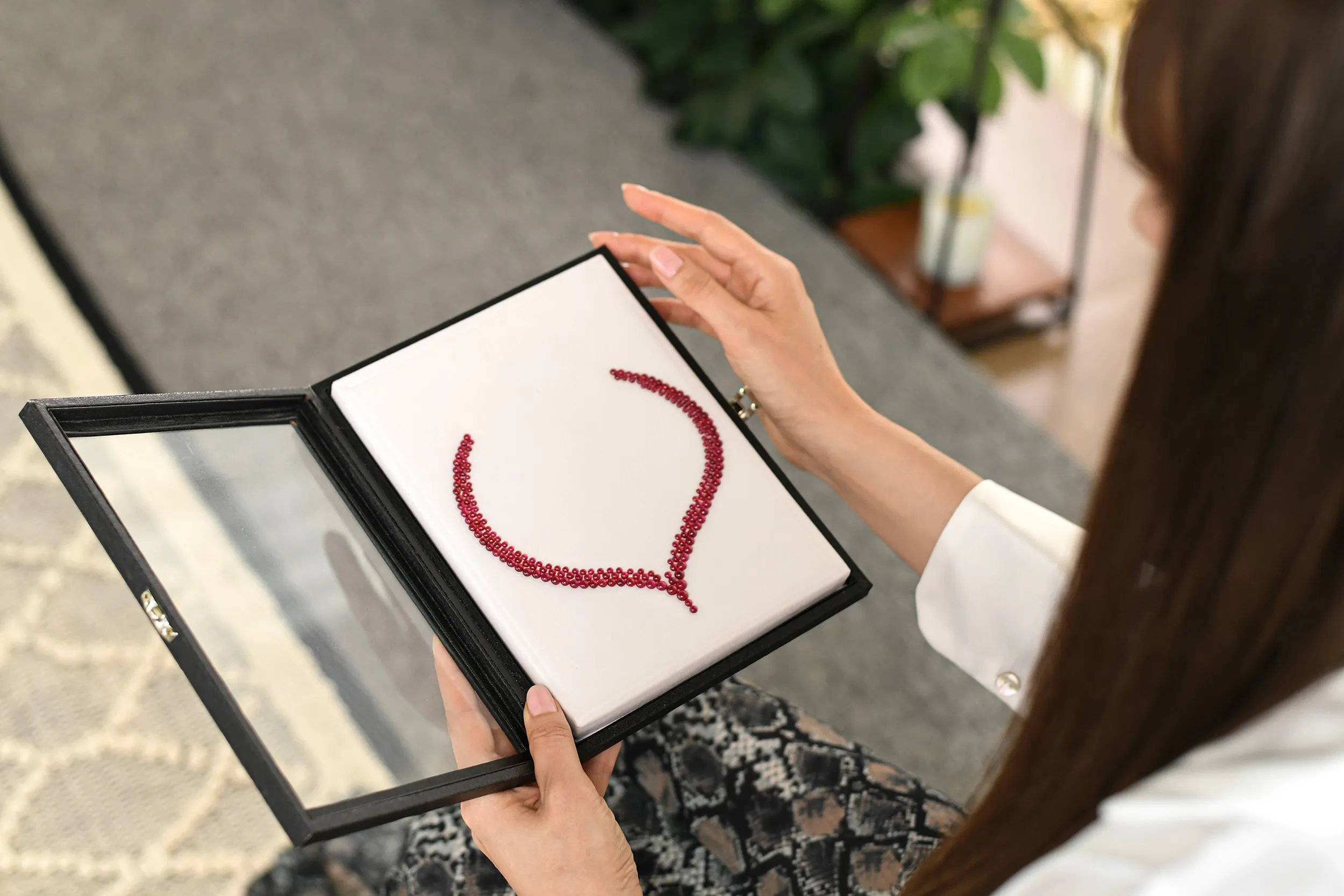 <p>Katerina Perez considers a layout of cabochon rubies perfectly matched by colour and carat weight, presented during a visit to Jaipur-based gem-cutting company Minehaus</p>
