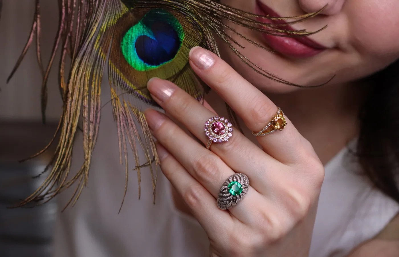 Katerina Perez wears a trio of rings with Malagasy coloured gemstones by Morebelli including (from left to right) a 1.68 carat emerald ring set with 196 diamonds, a ring set with a 1.35 carat pink tourmaline and 1.10 carats of pink sapphires, and a 3.03 carat golden sapphire ring with diamonds