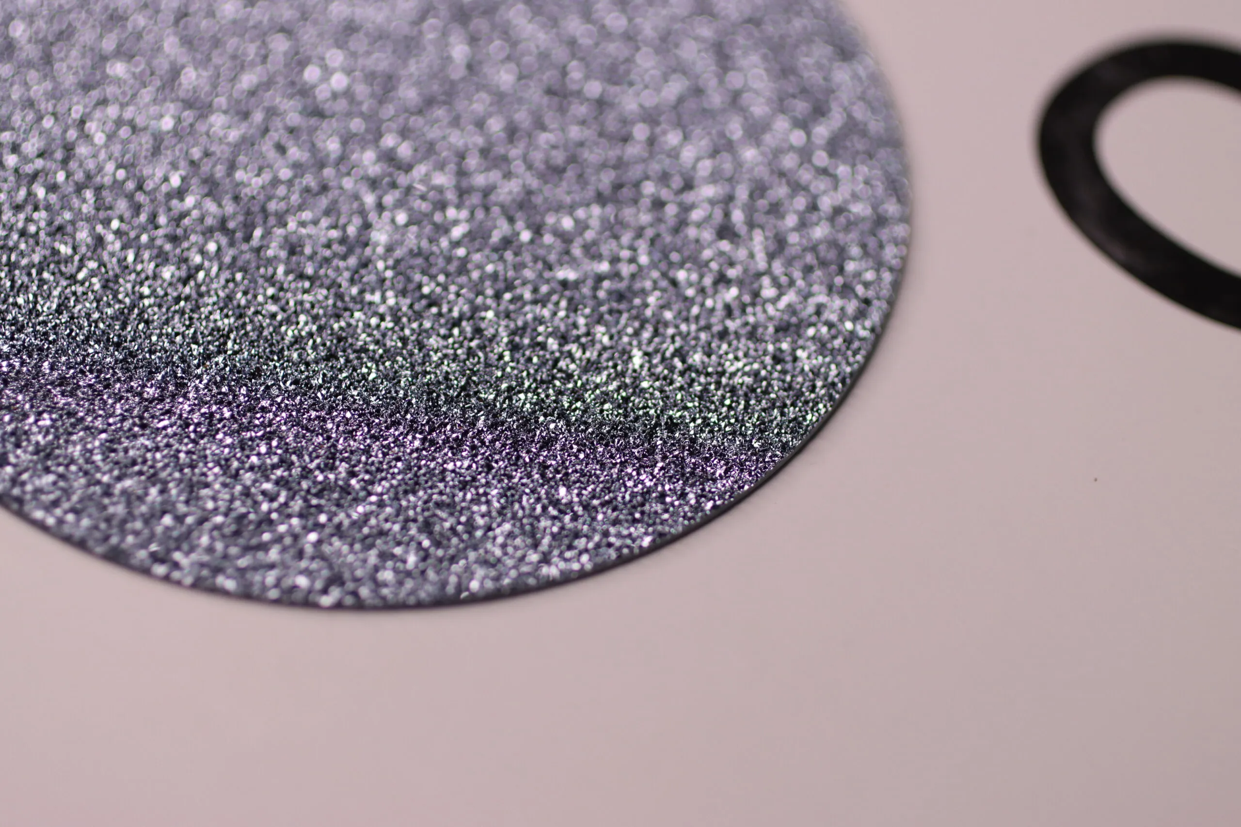 Close-up of a flat crystalline osmium disc, showing its surface