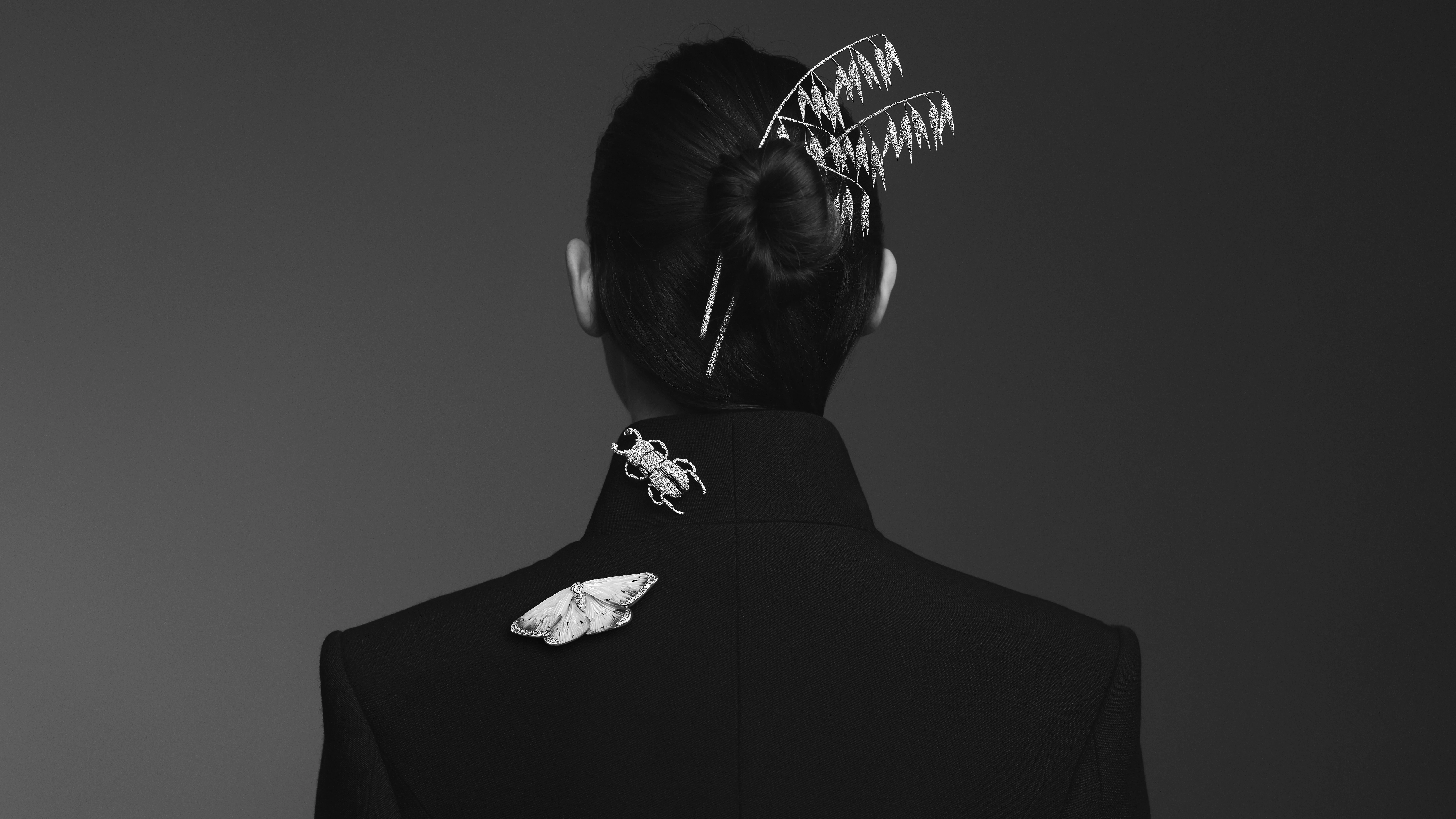 A model wears the Boucheron Avoine head jewel with diamonds in 18k white gold, alongside the Lucane (centre) and Papillon de Nuit brooches with mother of pearl, diamonds and black lacquer in 18k white gold, all part of the Untamed Nature Histoire de Style 2025 High Jewellery collection 