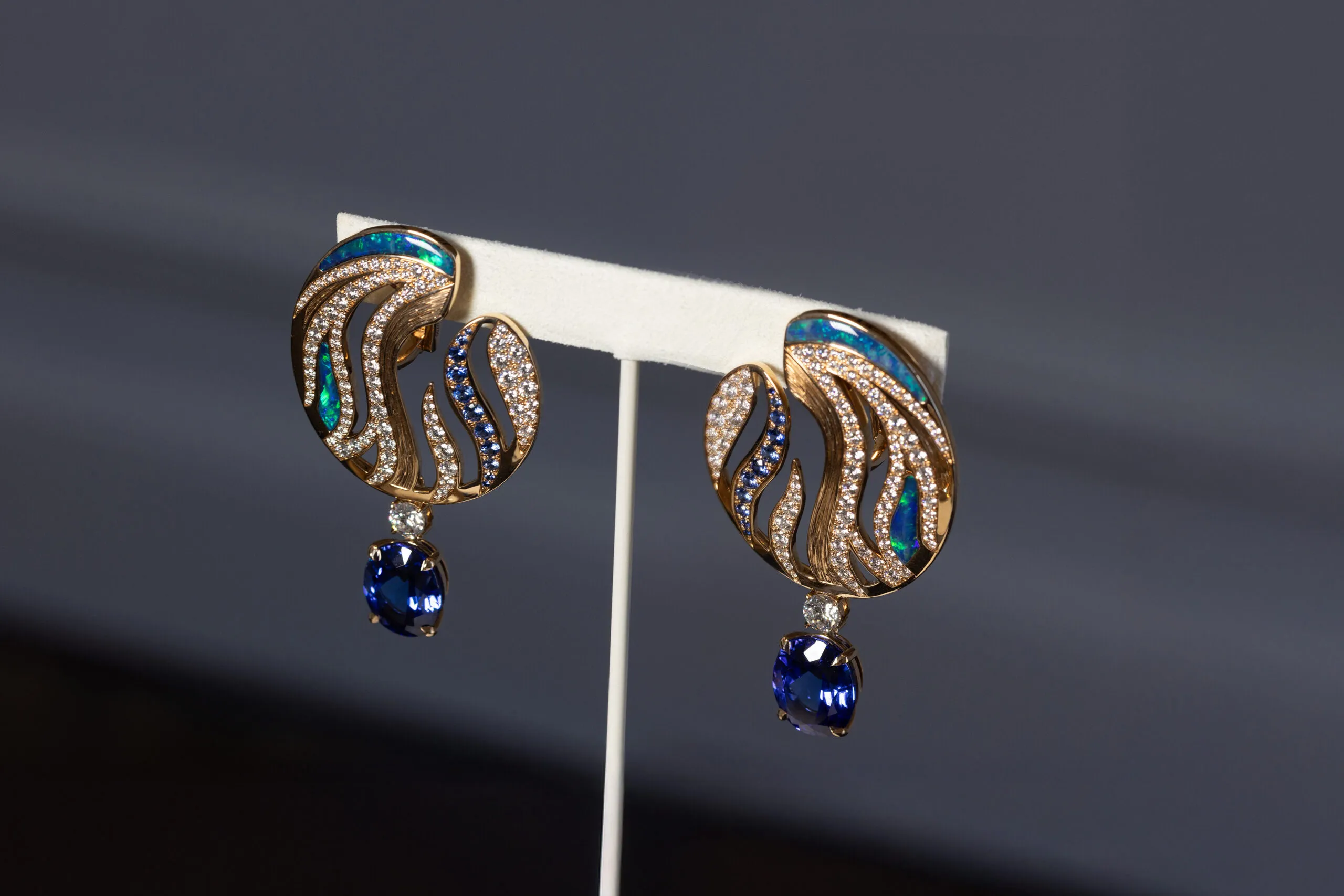 The matching high jewellery earrings feature psychedelic swirls of engraved gold, set with opal, diamonds and sapphires.