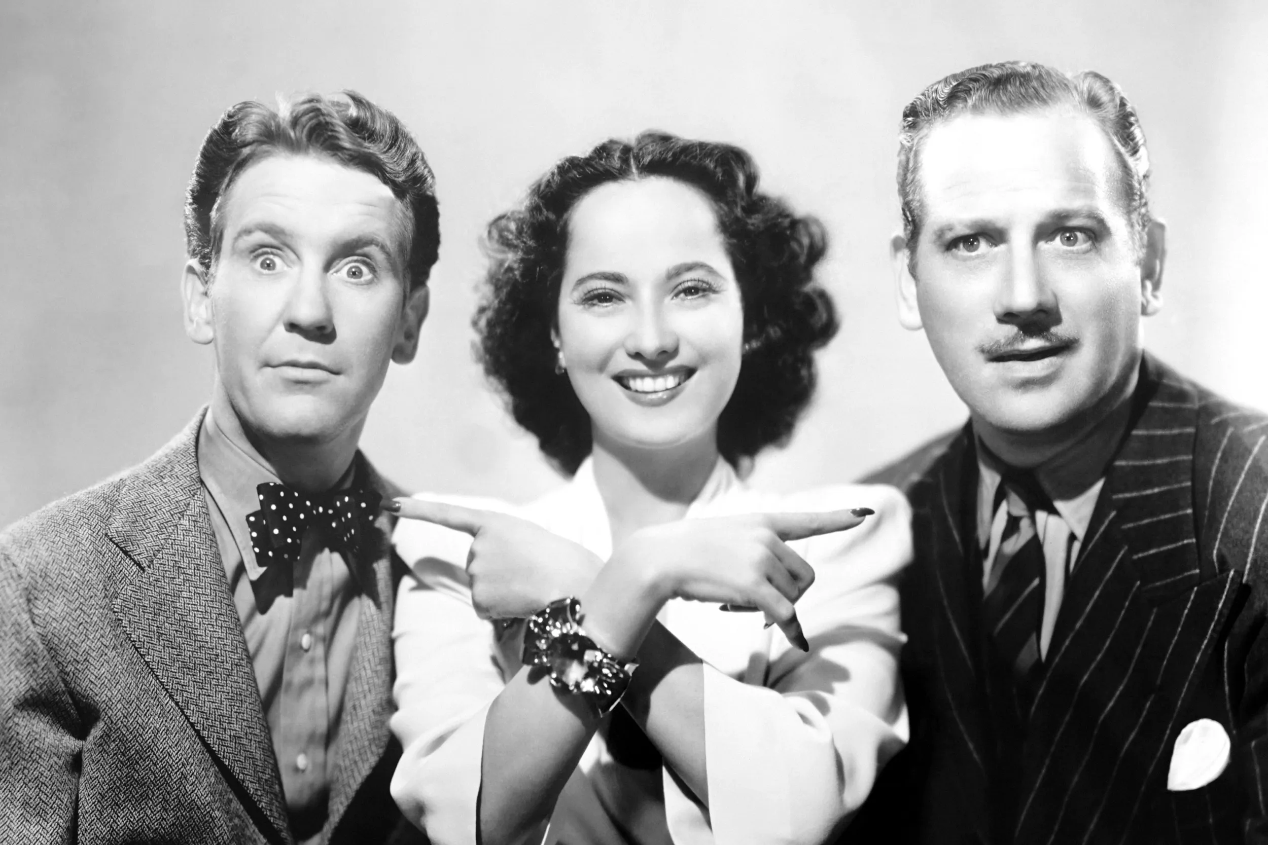 <p>Merle Oberon wears a gold-and-citrine bow bracelet by Paul Flato—now part of the Collection of Neil Lane—in a publicity still with Burgess Meredith and Melvyn Douglas for That Uncertain Feeling (1941). Photo: Everett Collection</p>