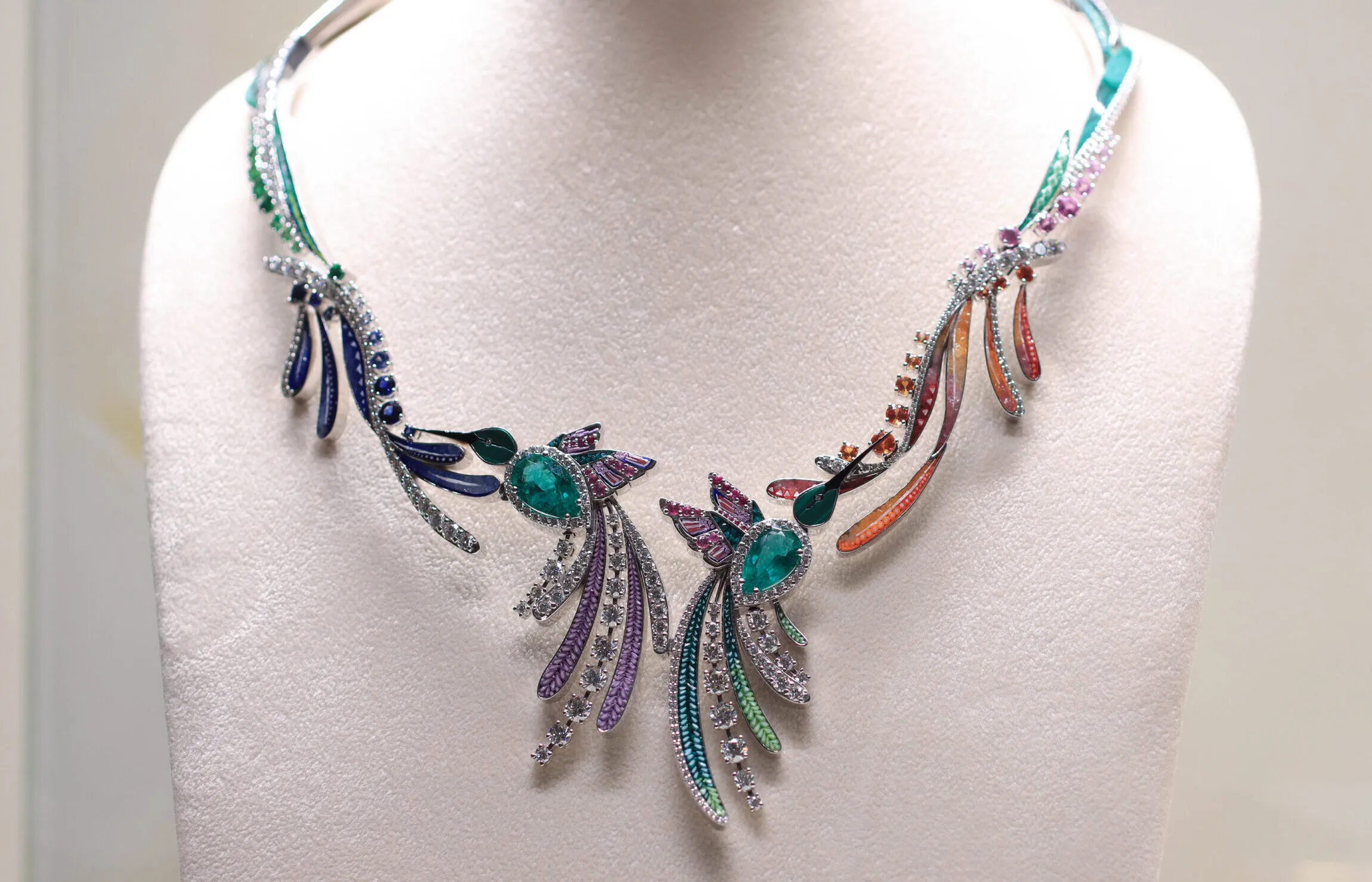 The SICIS Colibrì necklace is inspired by the iridescent plumage of hummingbirds with pear-shaped emeralds, malachite, micromosaics in shades of orange, pink, and green, multi-coloured sapphires and diamonds set in white gold 