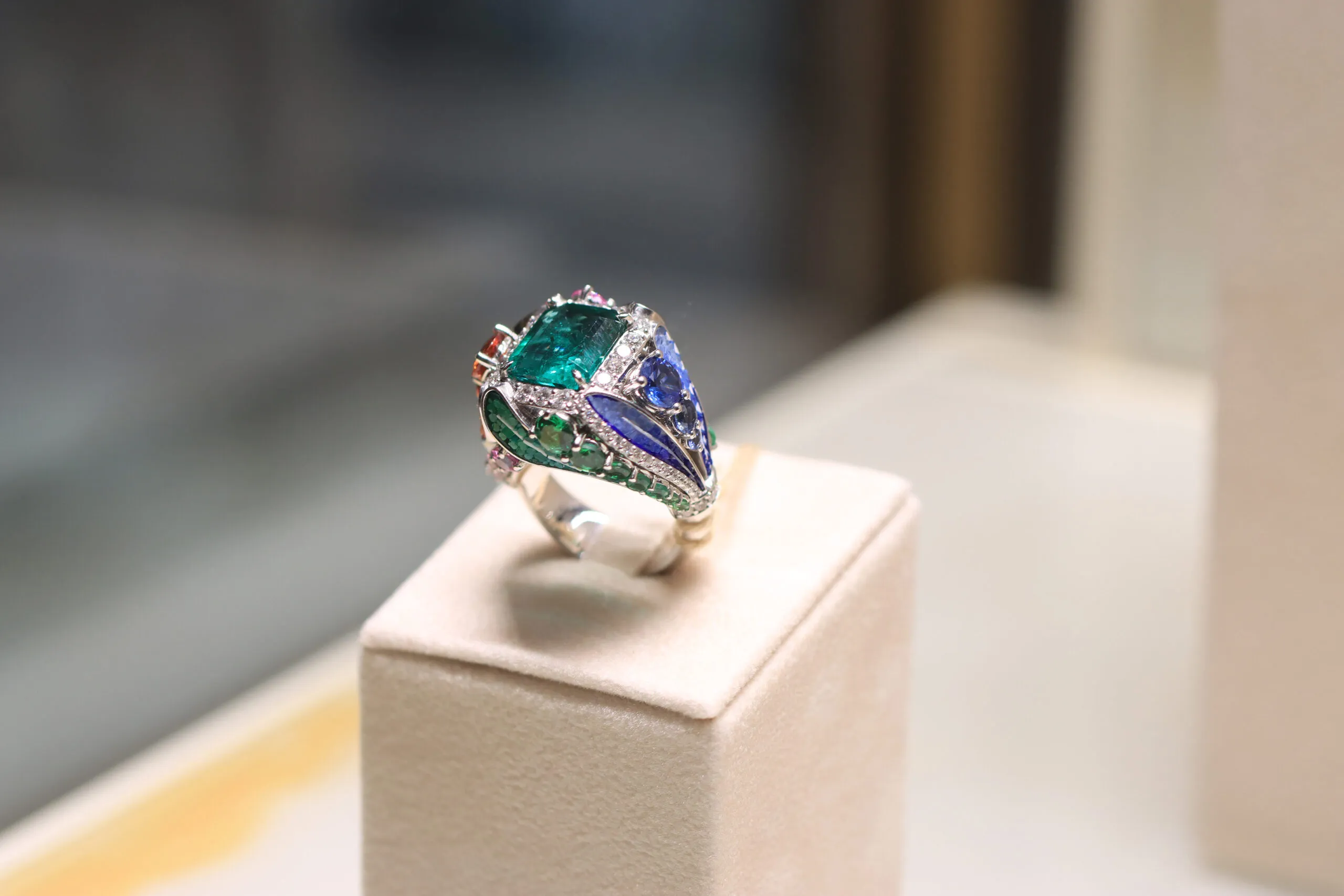 A closer look at the SICIS Colibrì ring inspired by tropical hummingbirds with an emerald centre stone, sapphires, further emeralds, diamonds, malachite and micromosaics in white gold