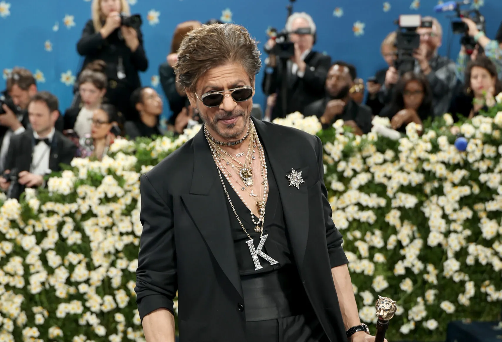 Bollywood star Shah Rukh Khan layered talismanic chains, including a 'K' pendant — a nod to his nickname, King Khan — a diamond Sabyasachi star brooch and a Bengal Tiger Head cane embellished with precious gems