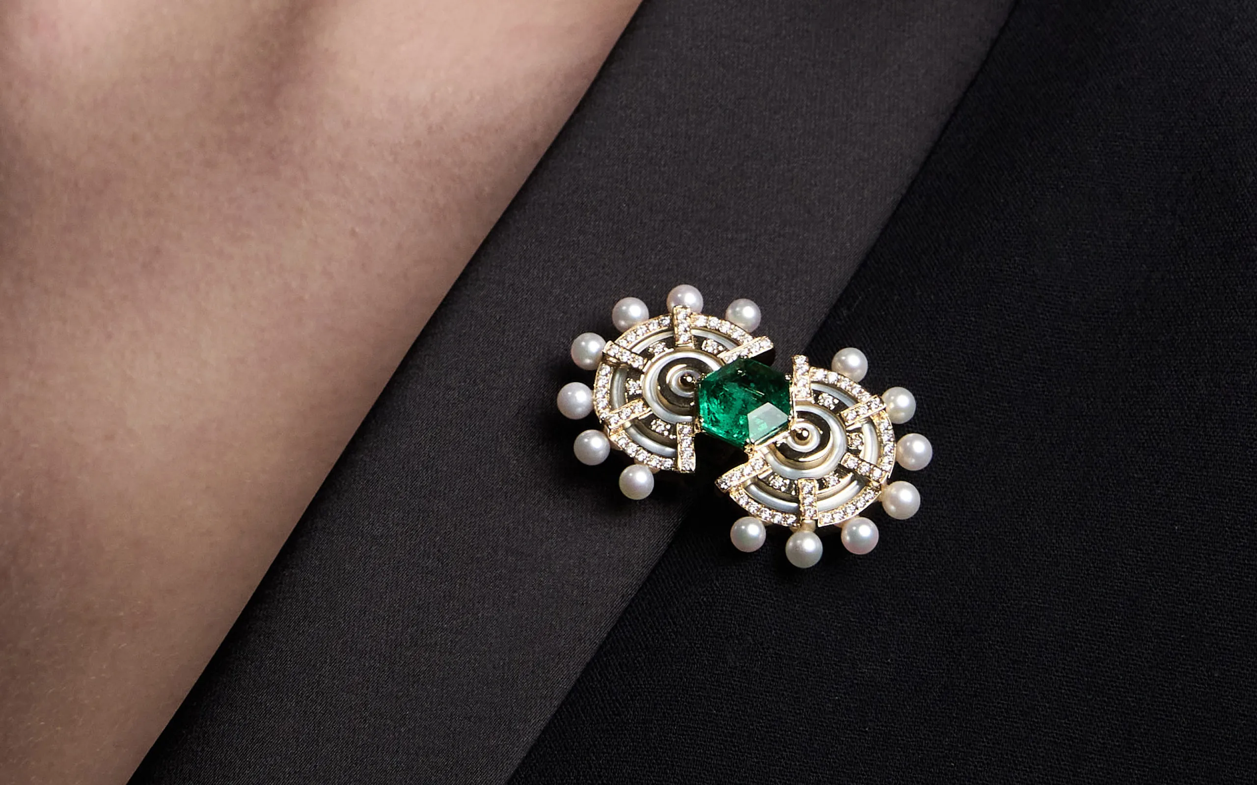 The State Property Raisina Snowdrop brooch, part of the Special Edition Gardens collection, is inspired by the blueprints of the Amrit Udyan gardens in India, featuring emeralds, diamonds, Akoya pearls, and mother of pearl in 18k gold