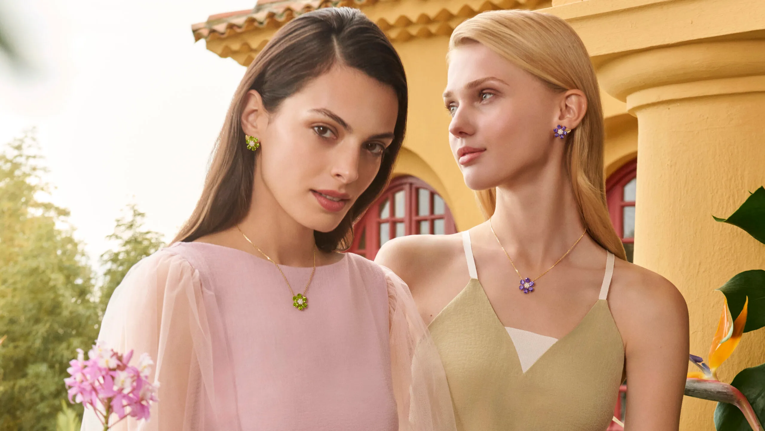 Models wear Van Cleef & Arpels Fleurs d’Hawaï amethyst and peridot necklace and earrings, crafted with diamonds in 18k yellow gold