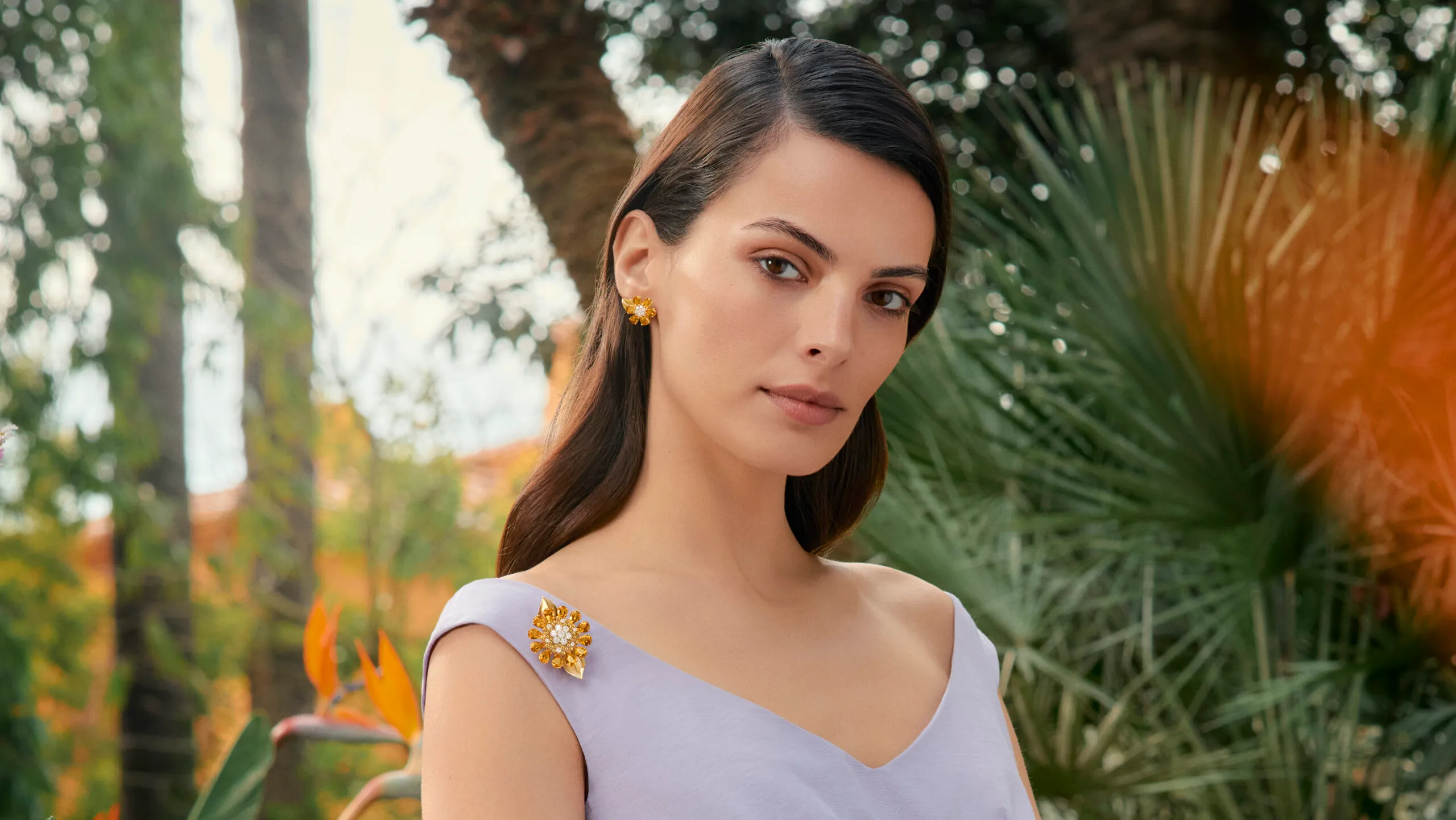 Model wears Van Cleef & Arpels Fleurs d’Hawaï secret watch, which doubles as a brooch or pendant, featuring citrine and diamonds in 18k white gold